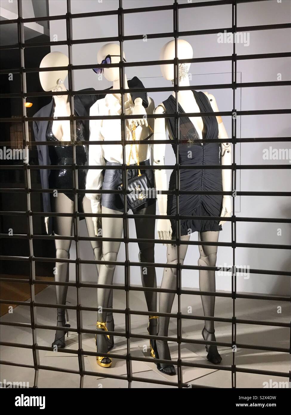 Three mannequins in the shop window of a closed shop - Smartphone Captured Stock Image