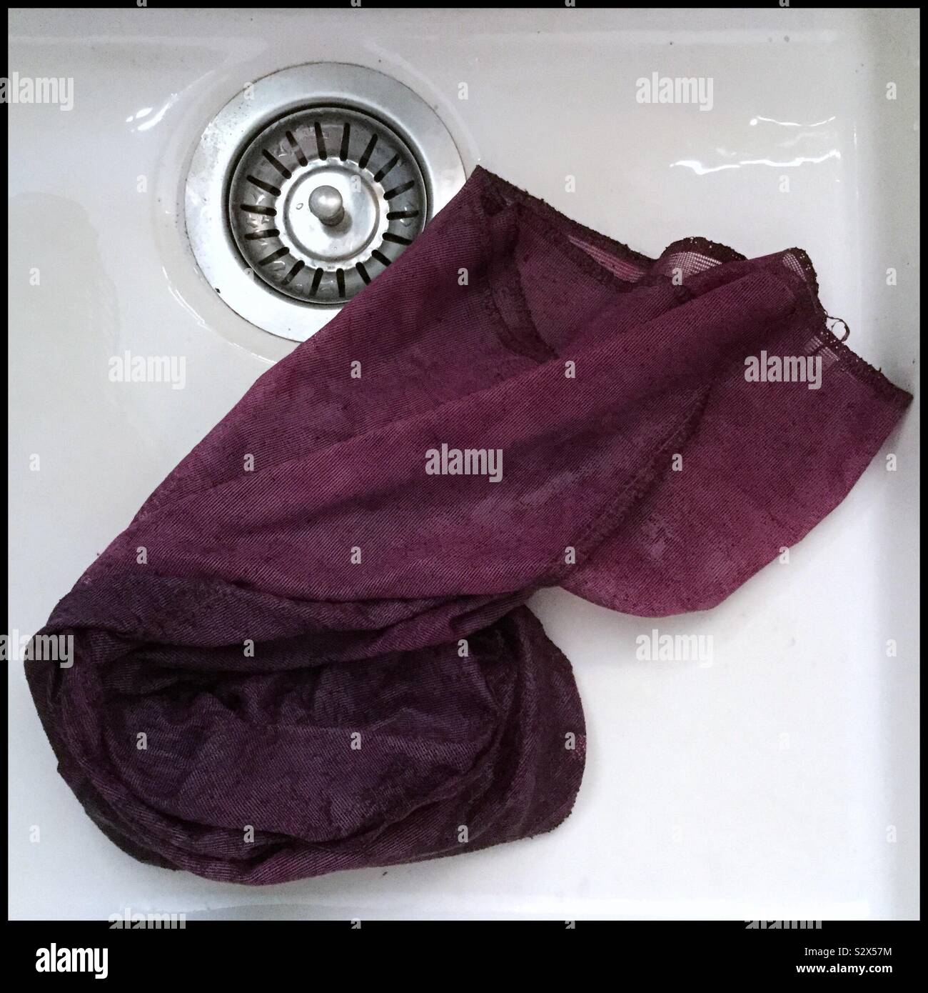 Mesh bag stained by new Syrah wine straight from a basket press, Catalonia, Spain. - Smartphone Captured Stock Image