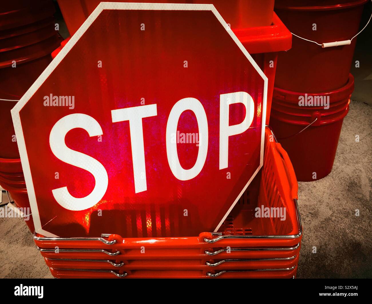 Stop sign displayed in a stack of plastic shopping baskets in a department store, USA - Smartphone Captured Stock Image