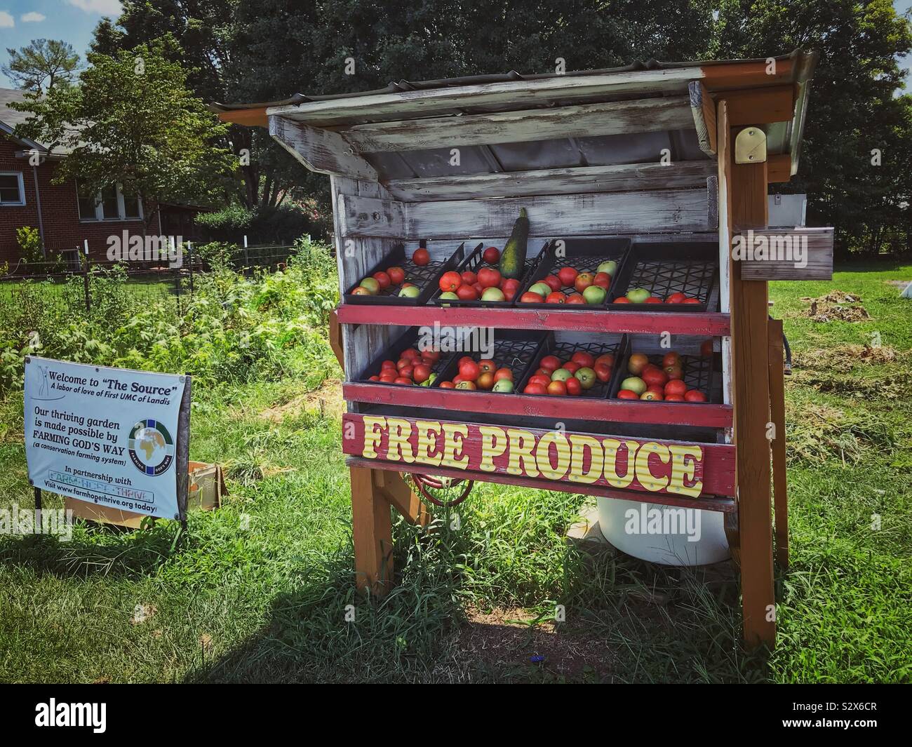 Church produce stand with sign and garden - Smartphone Captured Stock Image