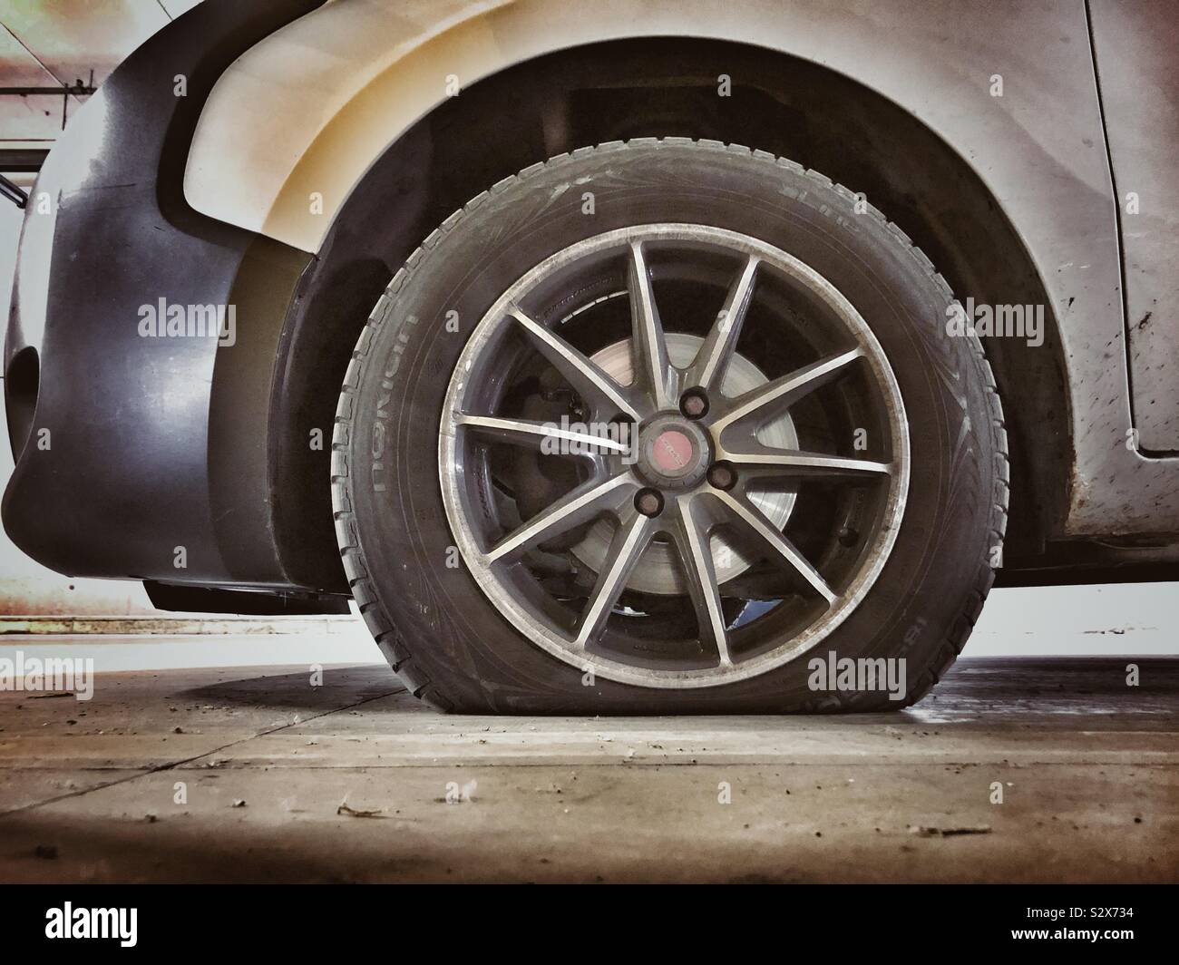 A car with a flat tyre tire Stock Photo