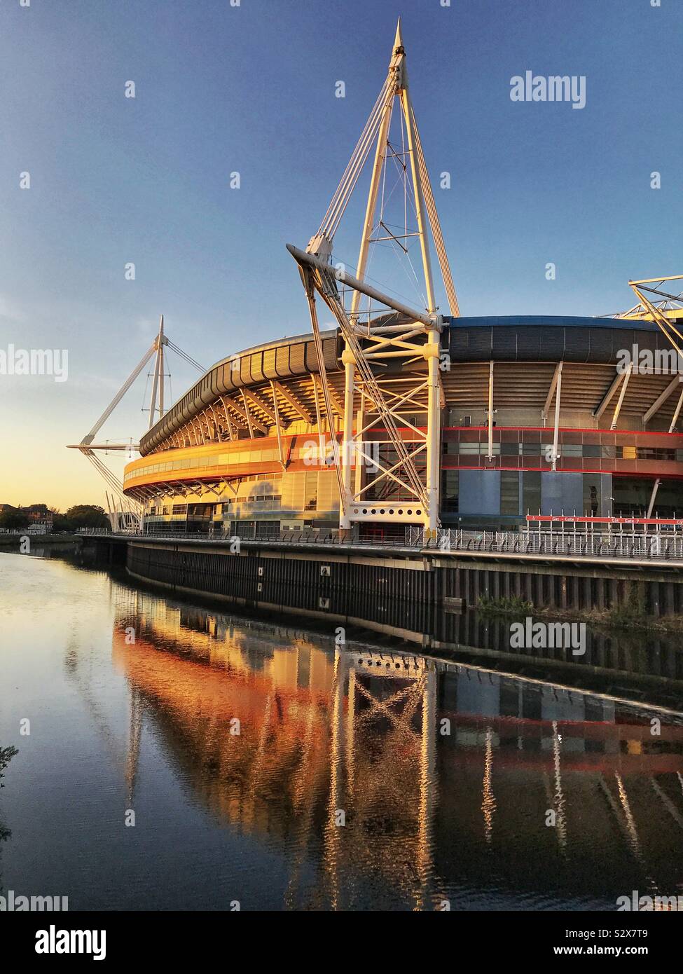 The Principality Stadium in Cardiff at sunset. It is located in the city centre on the banks of the River Taff Stock Photo
