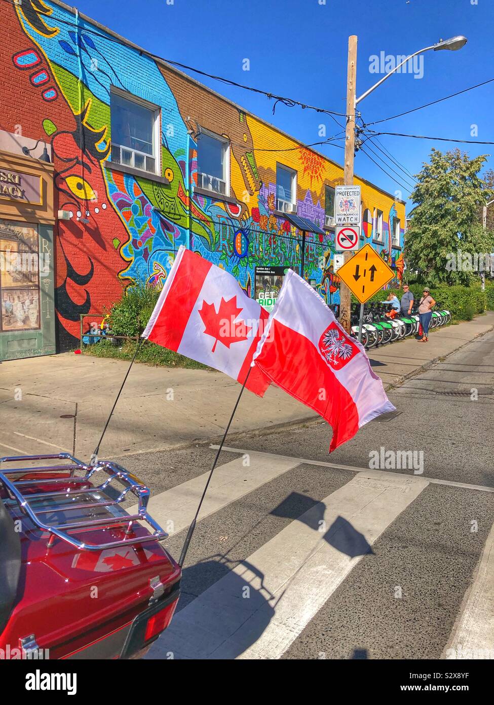 Canadian and Polish flags placed on the back of a motorbike during the annual Polish festival in a Toronto neighbourhood. - Smartphone Captured Stock Image
