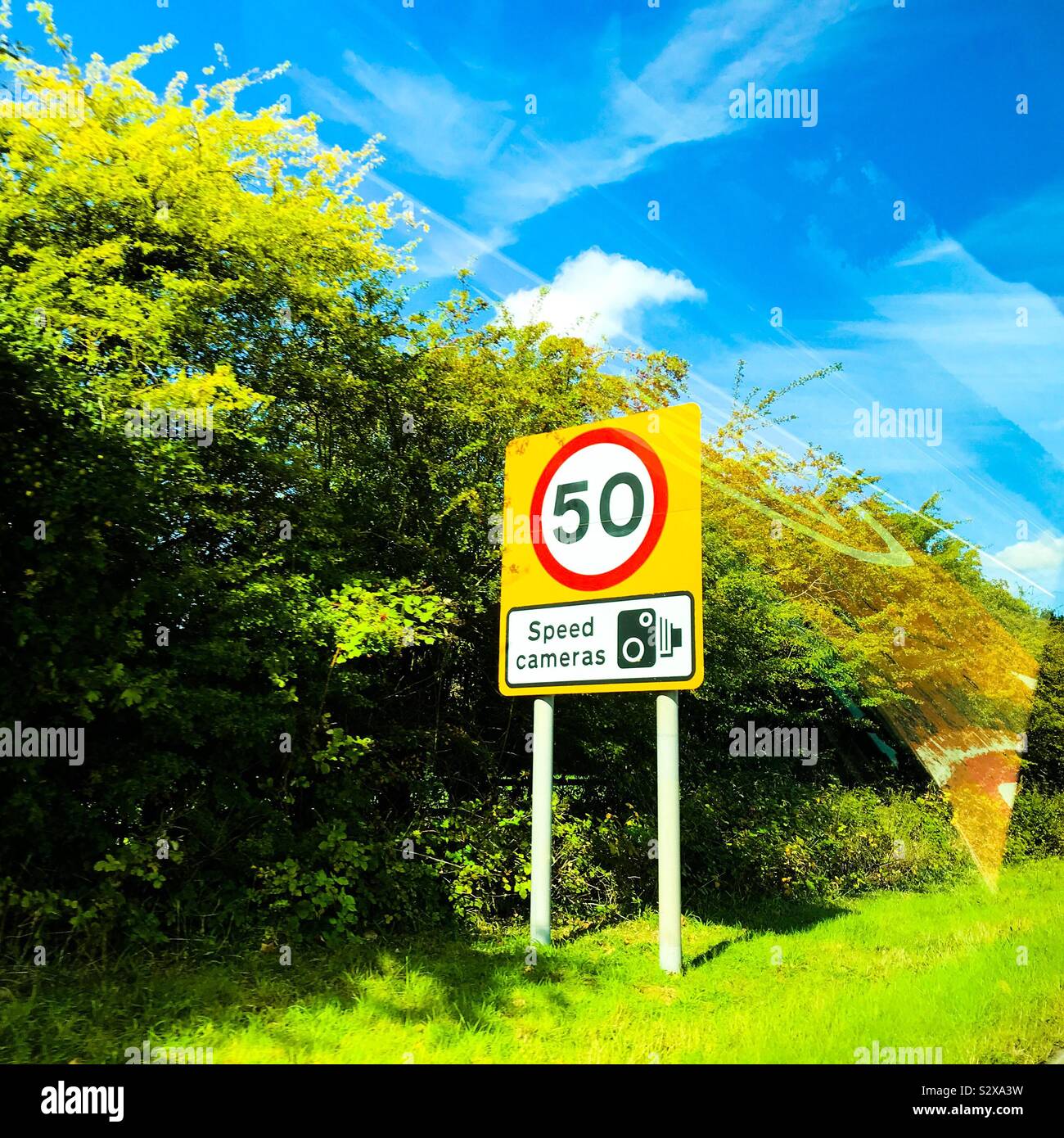 50 mph miles per hour speed camera zone warning sign signage on grass verge of motorway slip road Stock Photo