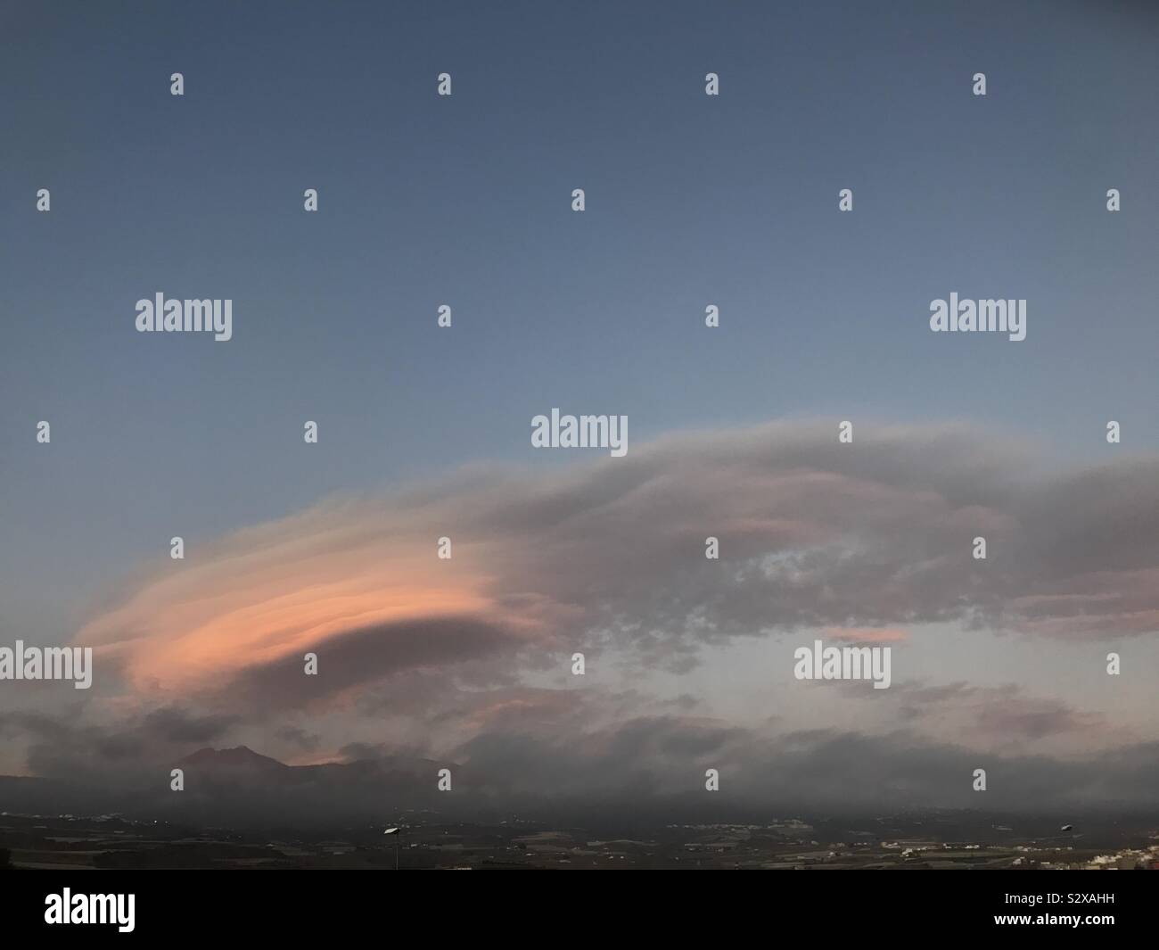 Lenticular clouds glowing red at sunset over mount Teide volcano on Tenerife, Canary Islands, Spain - Smartphone Captured Stock Image