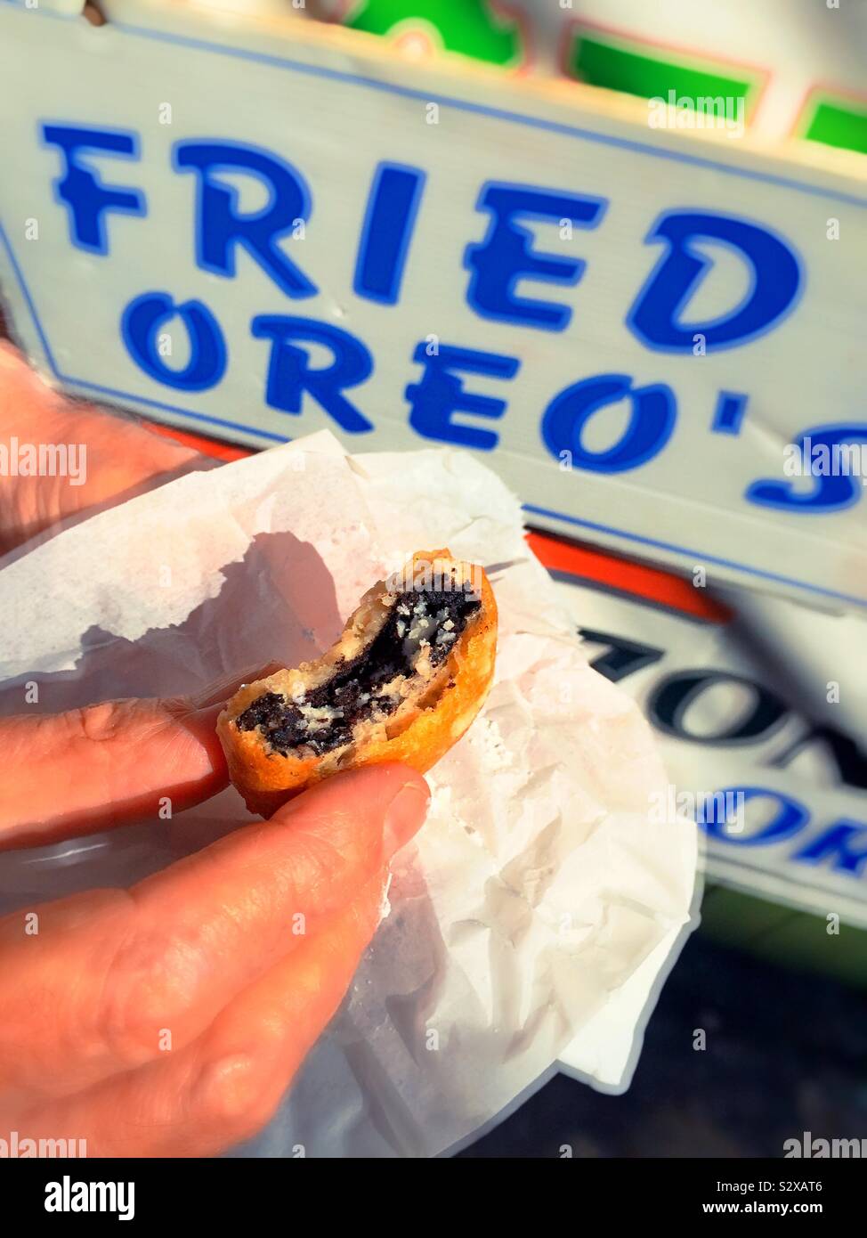Man holding a half eaten fried Oreo at the feast of San Gennaro on Mulberry Street in Little Italy, NYC, USA - Smartphone Captured Stock Image