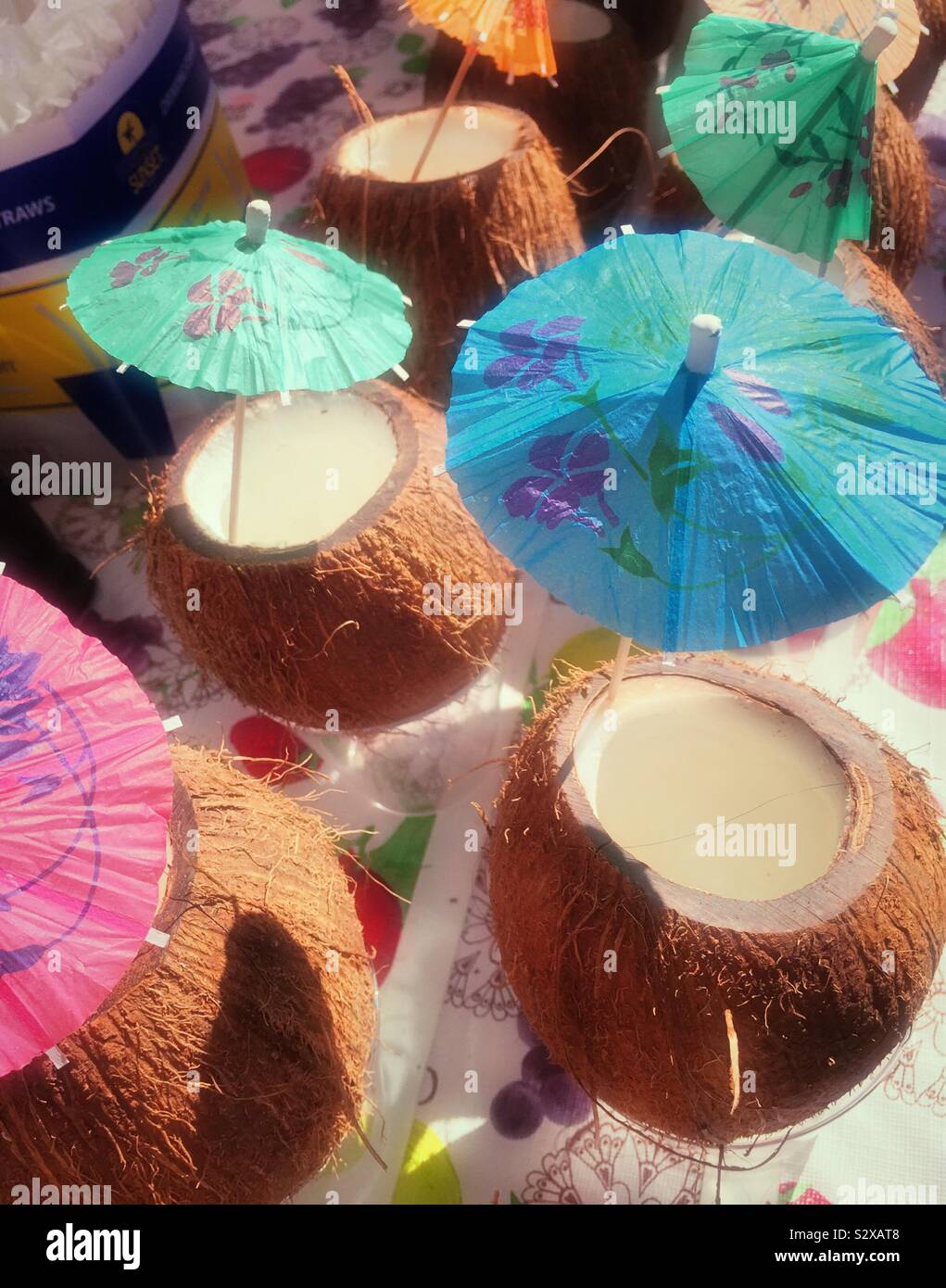 Tropical tiki bar cocktails served in a coconut shell glass with a tiny decorative umbrella, Little Italy, USA - Smartphone Captured Stock Image