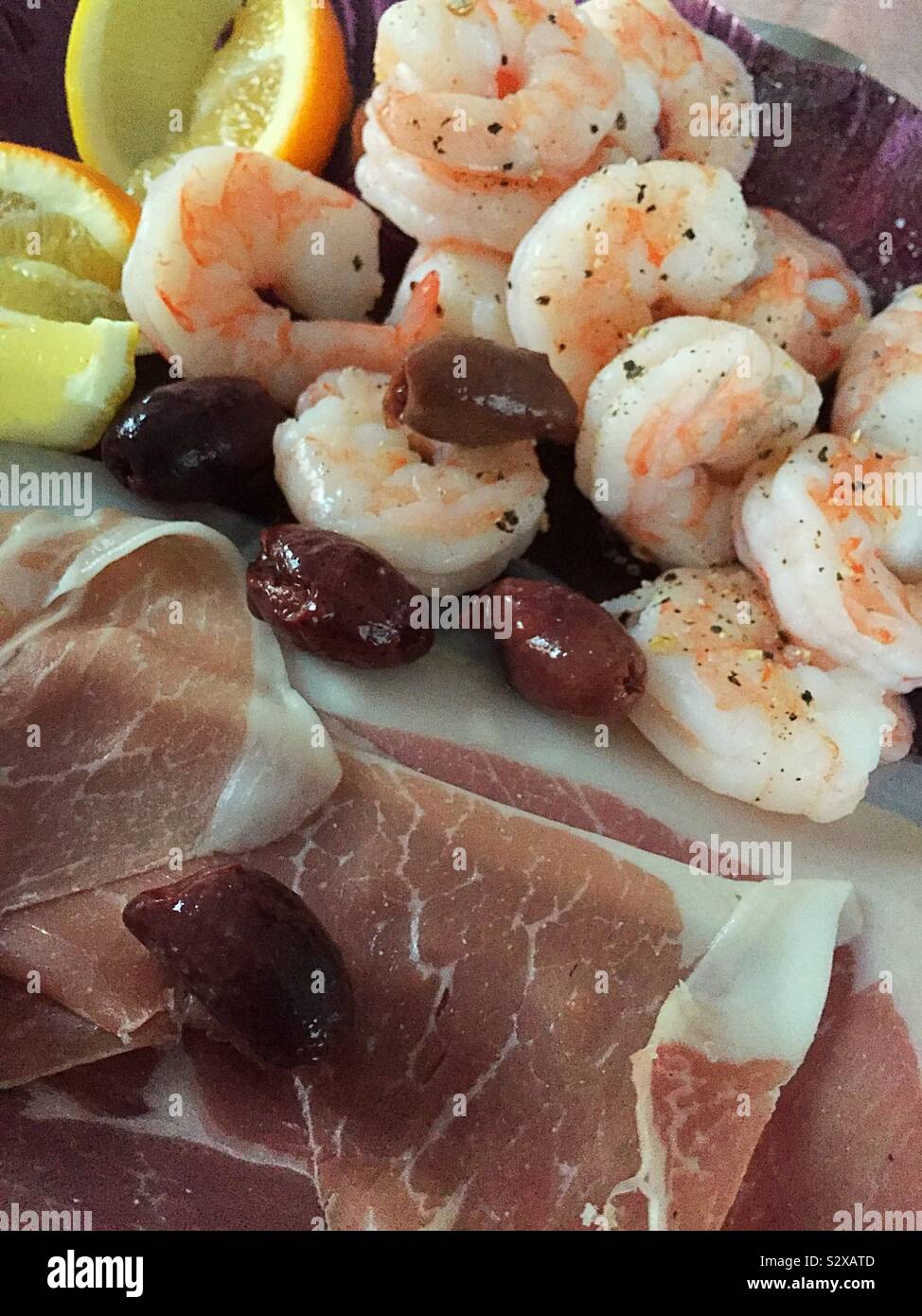 Fancy hors d’oeuvre platter of shrimp, Kalamata olives, prosciutto with lemon wedge garnish Stock Photo