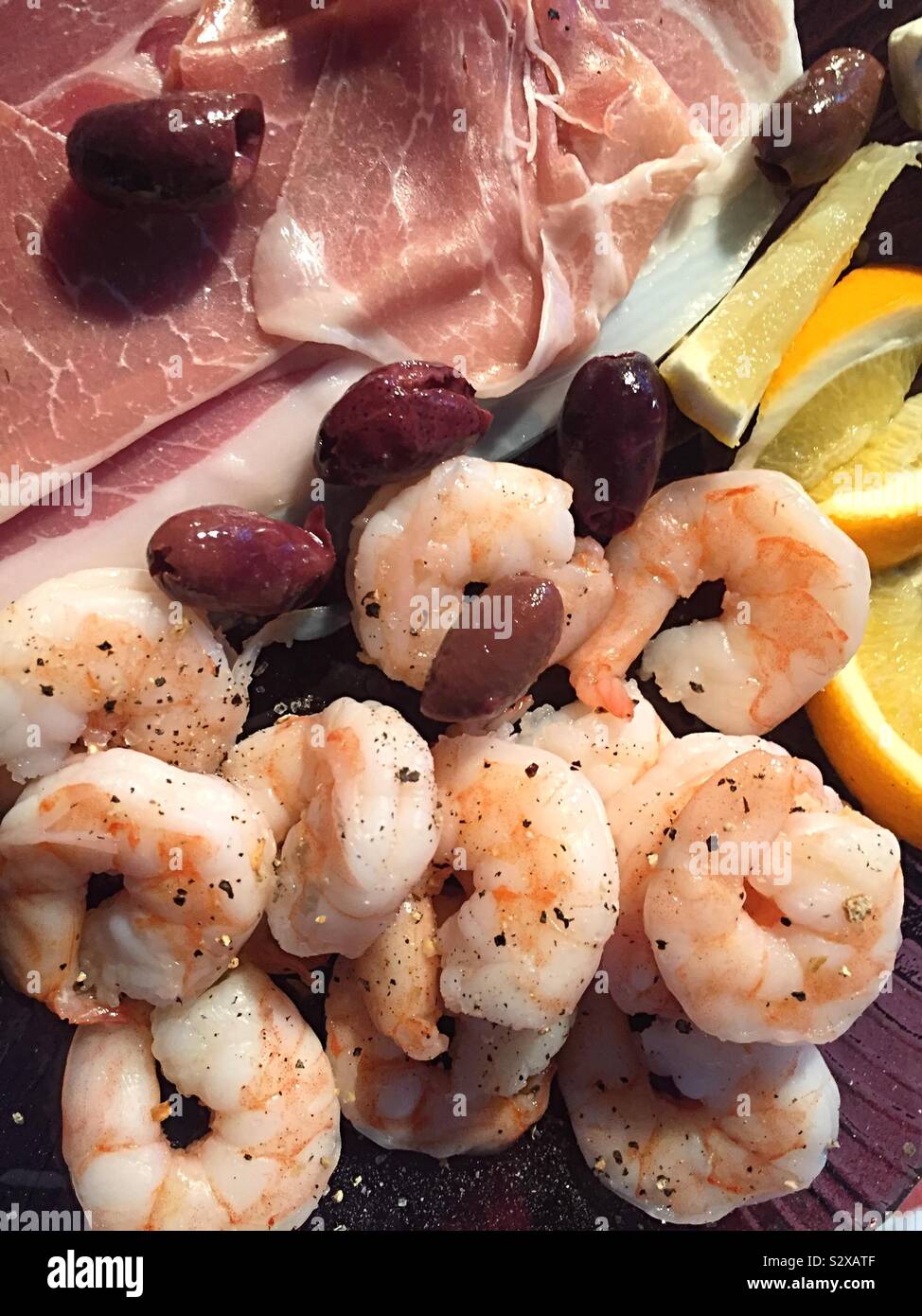 Fancy hors d’oeuvre platter of shrimp ,Kalamata olives, prosciutto with lemon wedges garnish Stock Photo