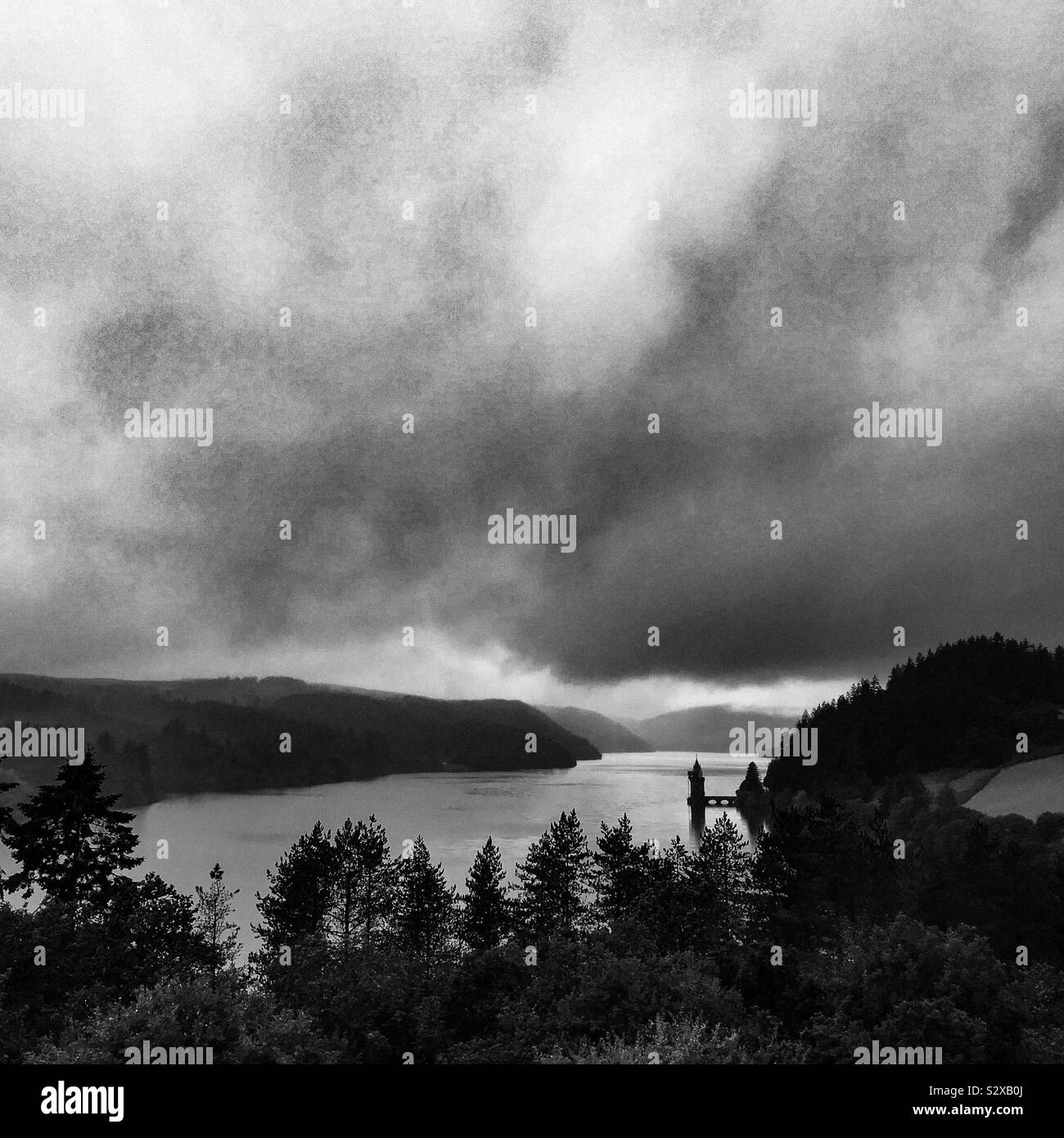 Lake Vyrnwy in Wales; an atmospheric sky over the Victorian straining tower in monochrome black and white Stock Photo