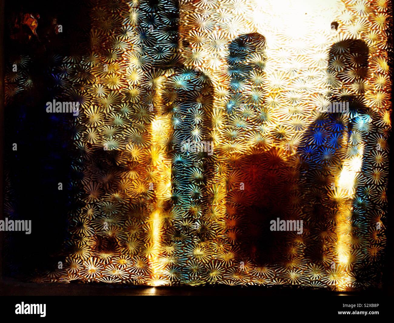 Backlit bottles of spirits in a bar through glass patterned pane. Nancys’s Bar , Ardara, County Donegal, Ireland - Smartphone Captured Stock Image