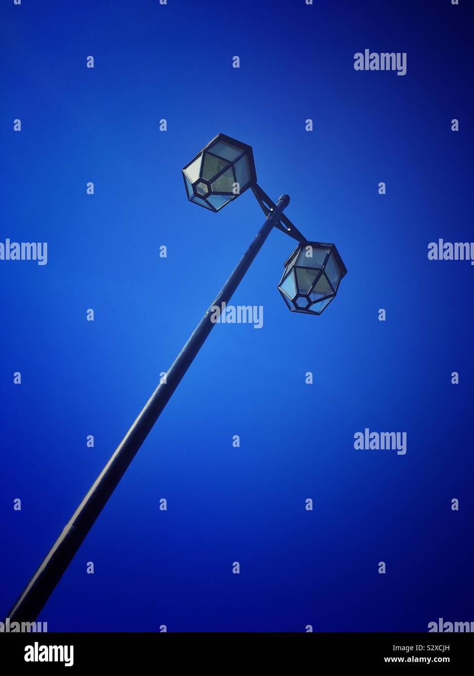 Old style street light isolated against deep blue sky - Smartphone Captured Stock Image