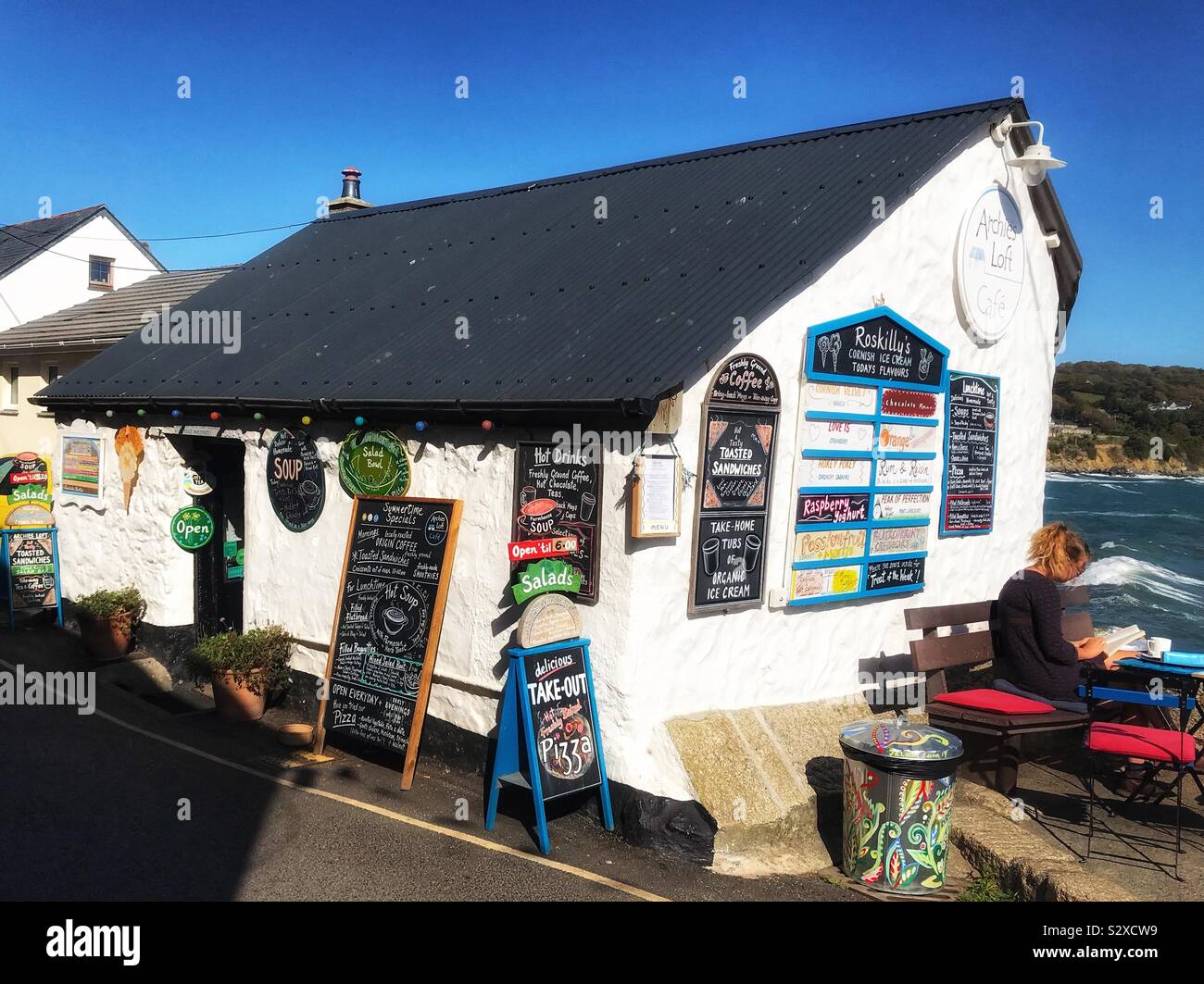 Archie’s Loft Cafe At Coverack In Cornwall UK - Small Cafe overlooking the fishing Harbour with Menu boards outside - Smartphone Captured Stock Image