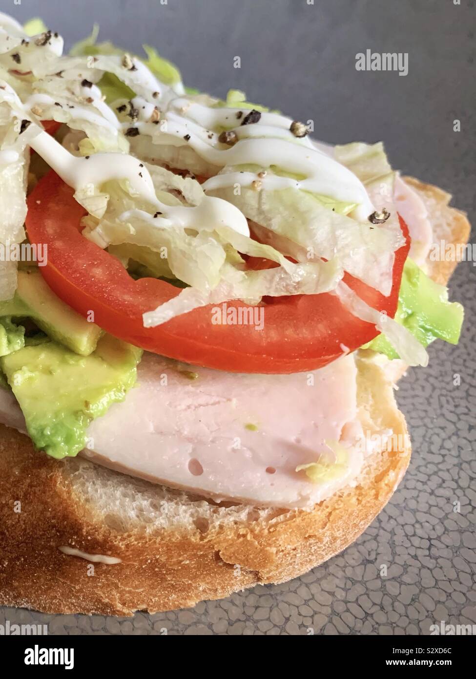 Chicken avocado tomato and lettuce open sandwich with mayo Stock Photo