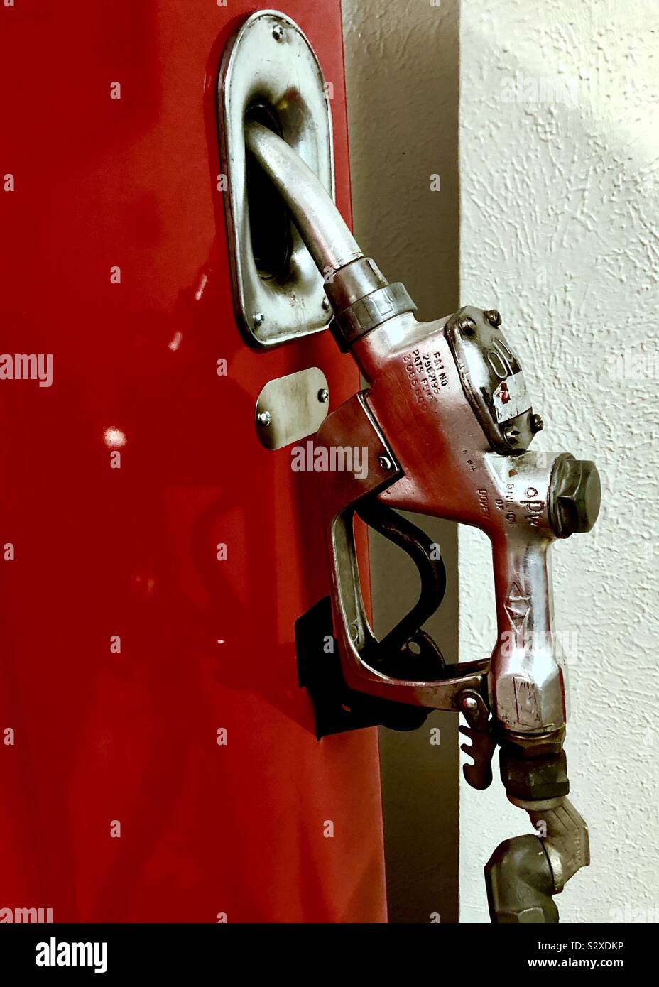 Antique gasoline nozzle on red and white background Stock Photo