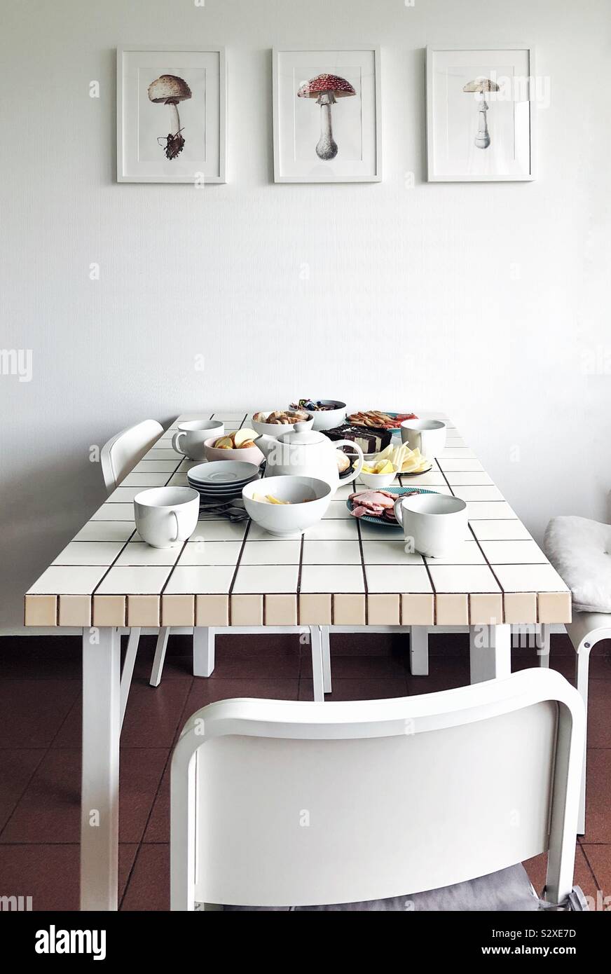 Modern design white kitchen with table set for tea Stock Photo