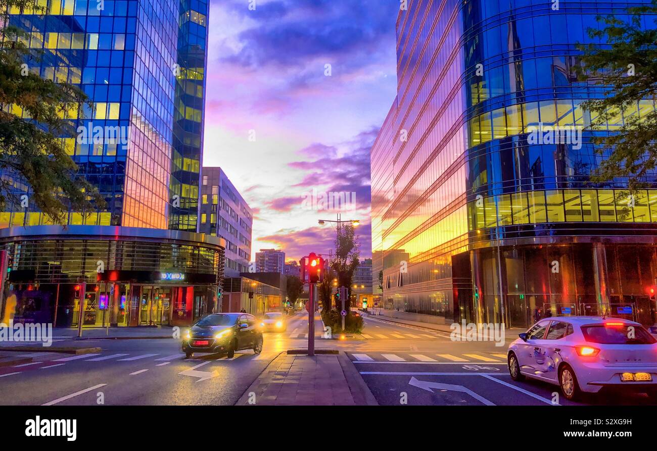 Colorful morning sky over the city streets, reflected in the glass windows of the office buildings of the business district of Brussels - Smartphone Captured Stock Image