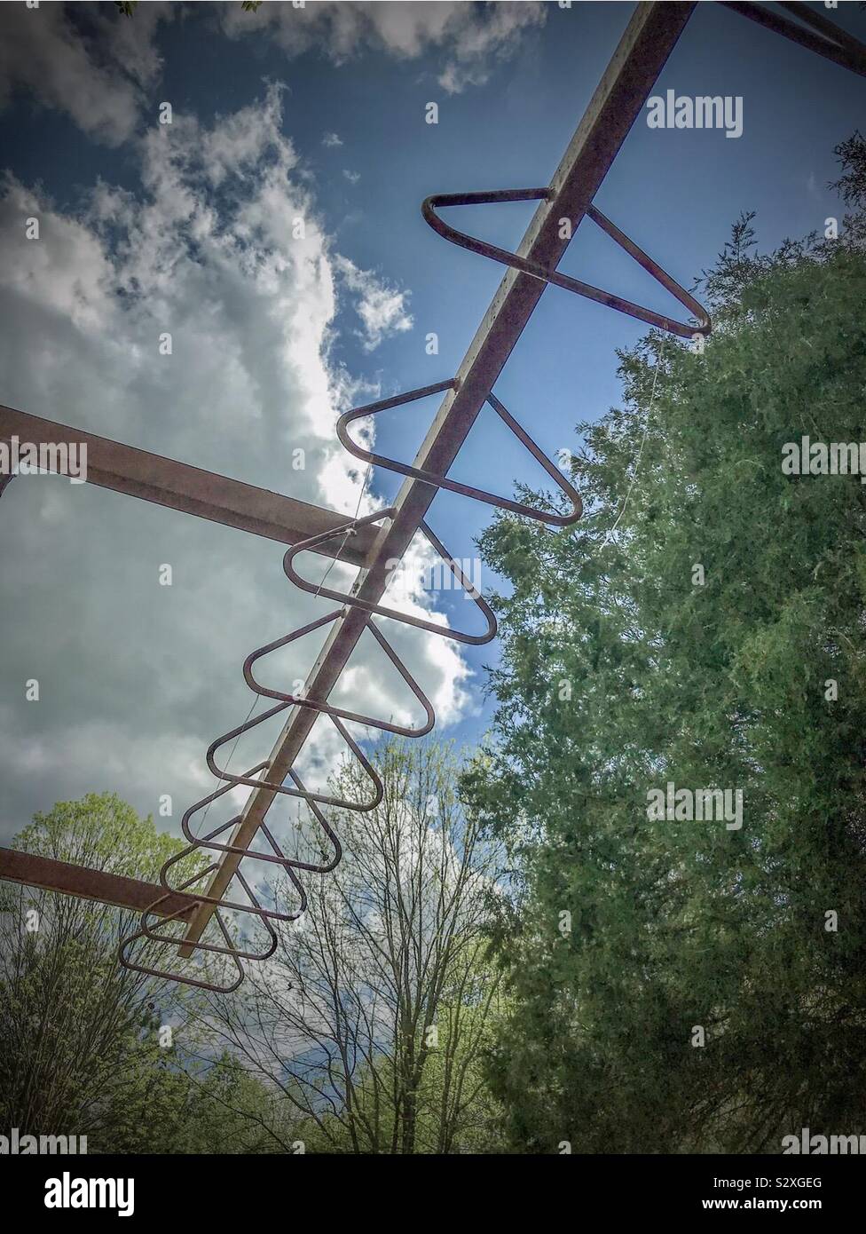 Overhand bars, sky, and trees in playground Stock Photo