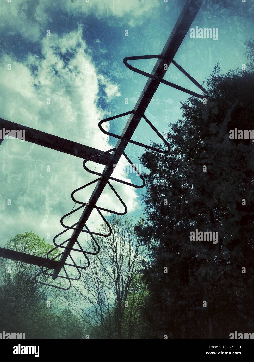 Grunge photo of overhand bars, sky, and trees in a playground Stock Photo