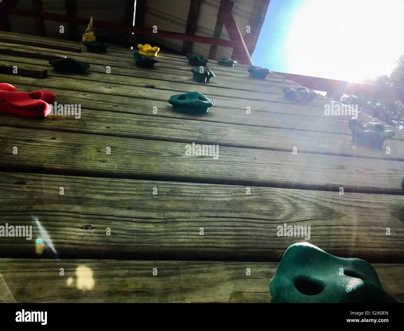 Sunlight and a view up the climbing wall at playground Stock Photo