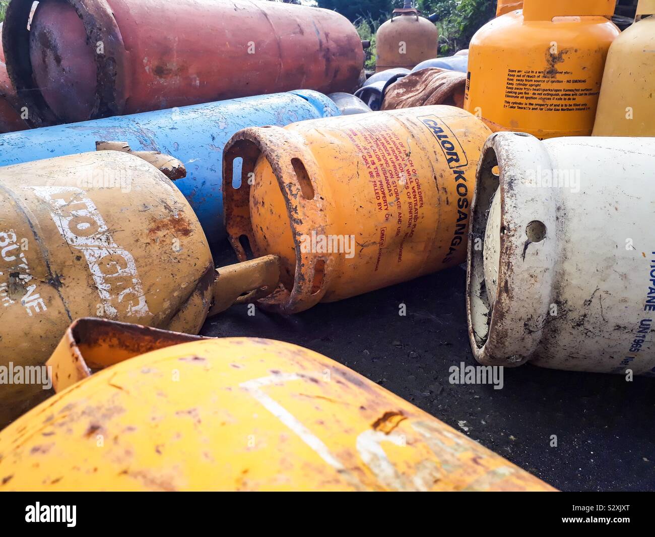 Old, rusty gas bottles on scrapyard. Stock Photo