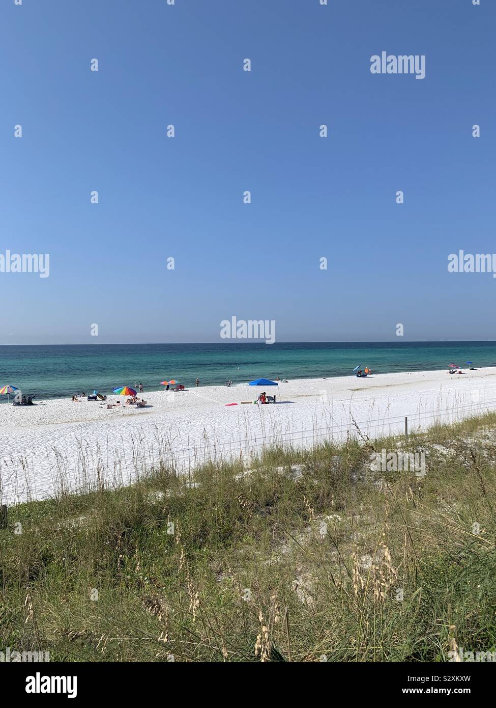 Seascape of white sand beach with view of people enjoying the beach - Smartphone Captured Stock Image