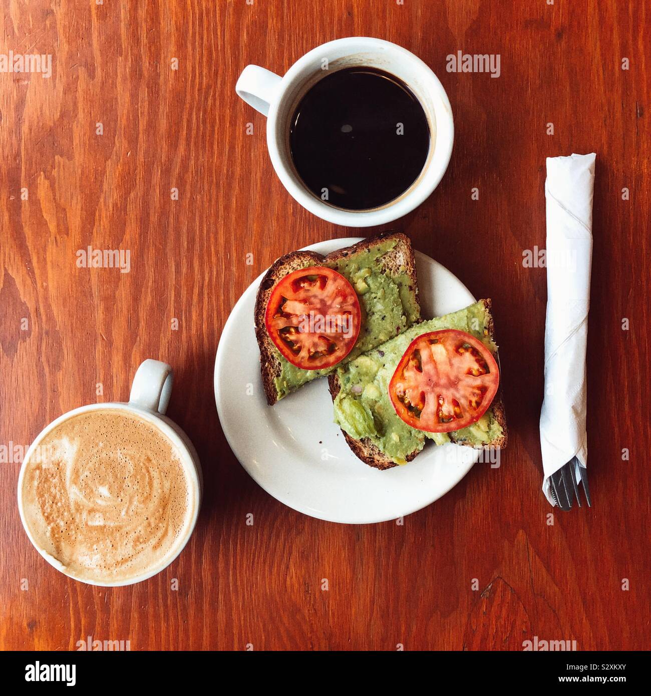 Classical  avocado toast breakfast flatlay on wooden table Stock Photo