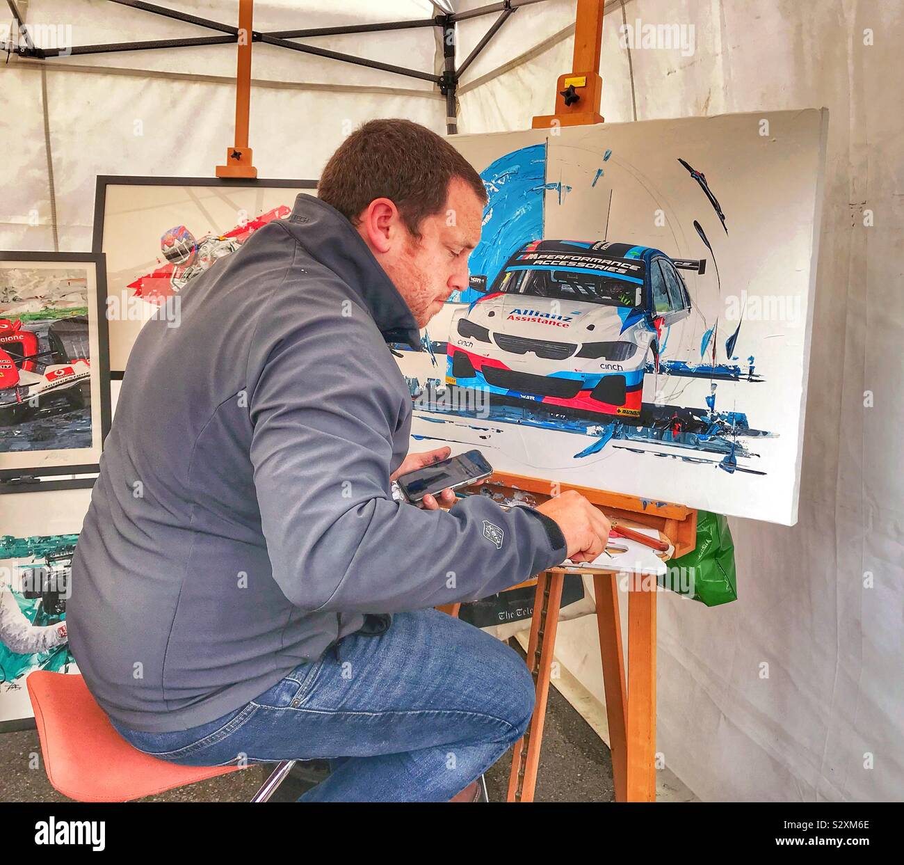 Man Painting a BMW Touring Car At Silverstone UK 2019 - Smartphone Captured Stock Image