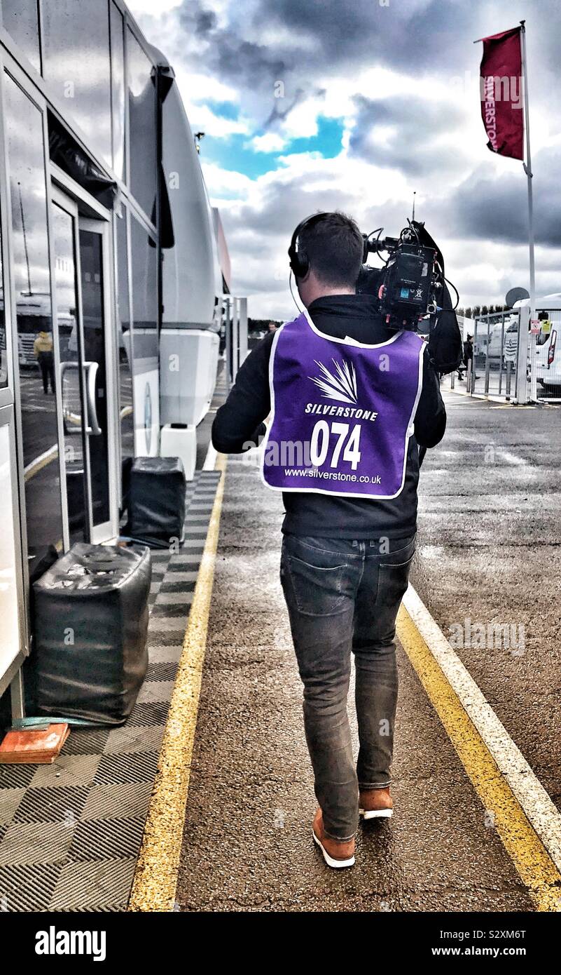 Cameraman Walking With Camera On His Shoulder At The BTCC - Silverstone UK 2019 - Smartphone Captured Stock Image