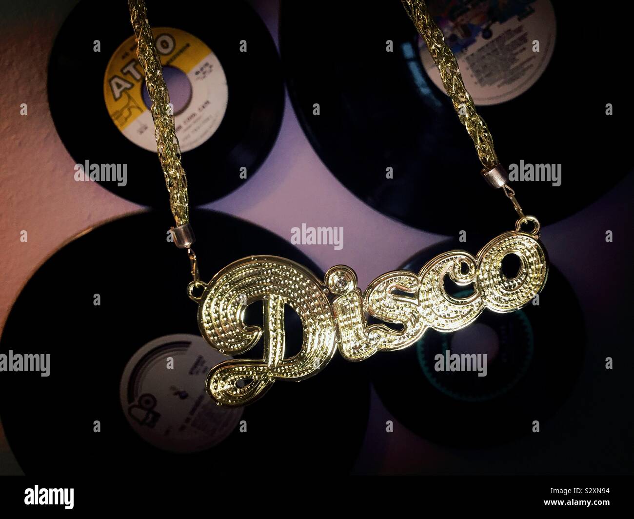 Disco Gold colored chain hanging in front of vintage vinyl records, USA Stock Photo