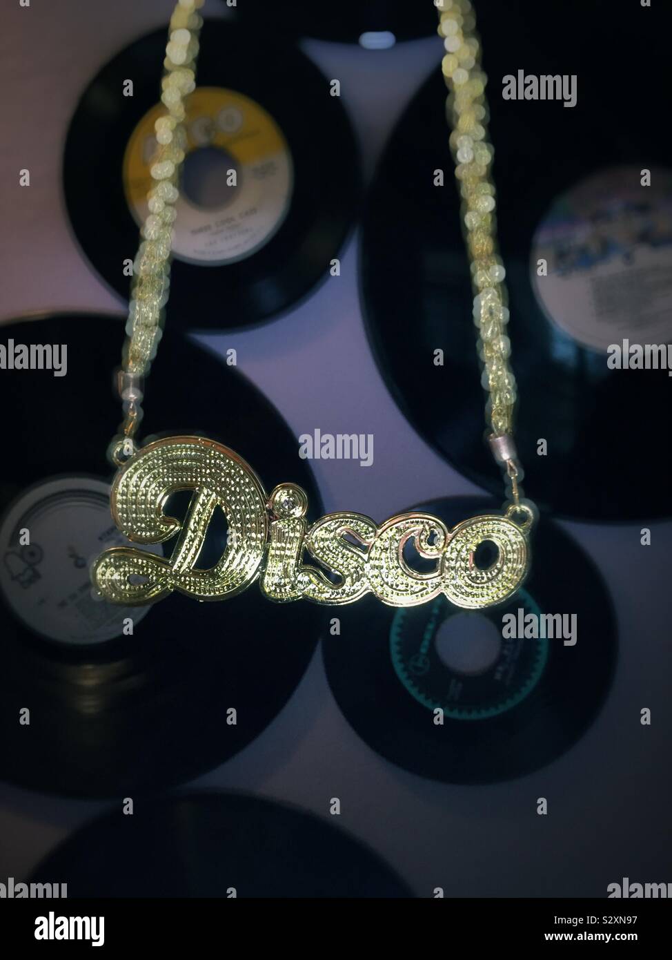 Close up of a gold disco chain in front of a vinyl records, USA Stock Photo