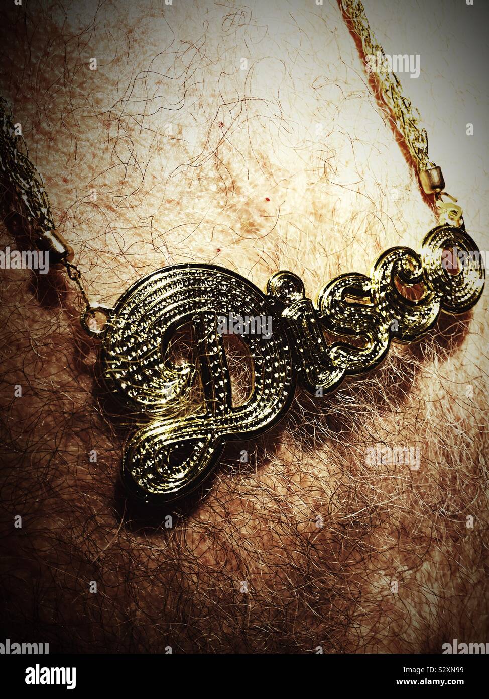 Closeup of a disco chain around an old rocker’s Bare hairy chest, USA