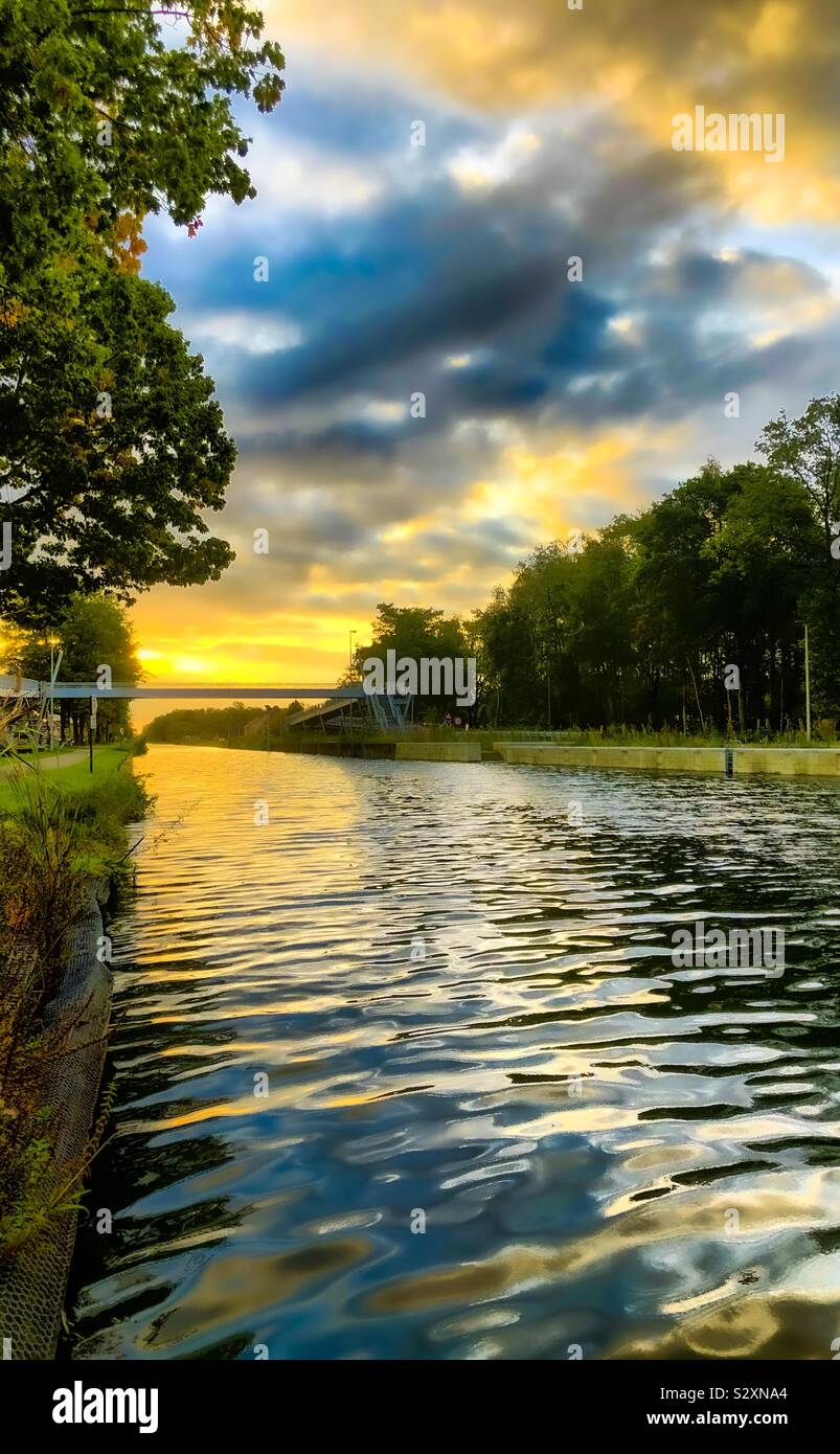 Dark stormy clouds and a golden sunrise combined in the sky over a ...