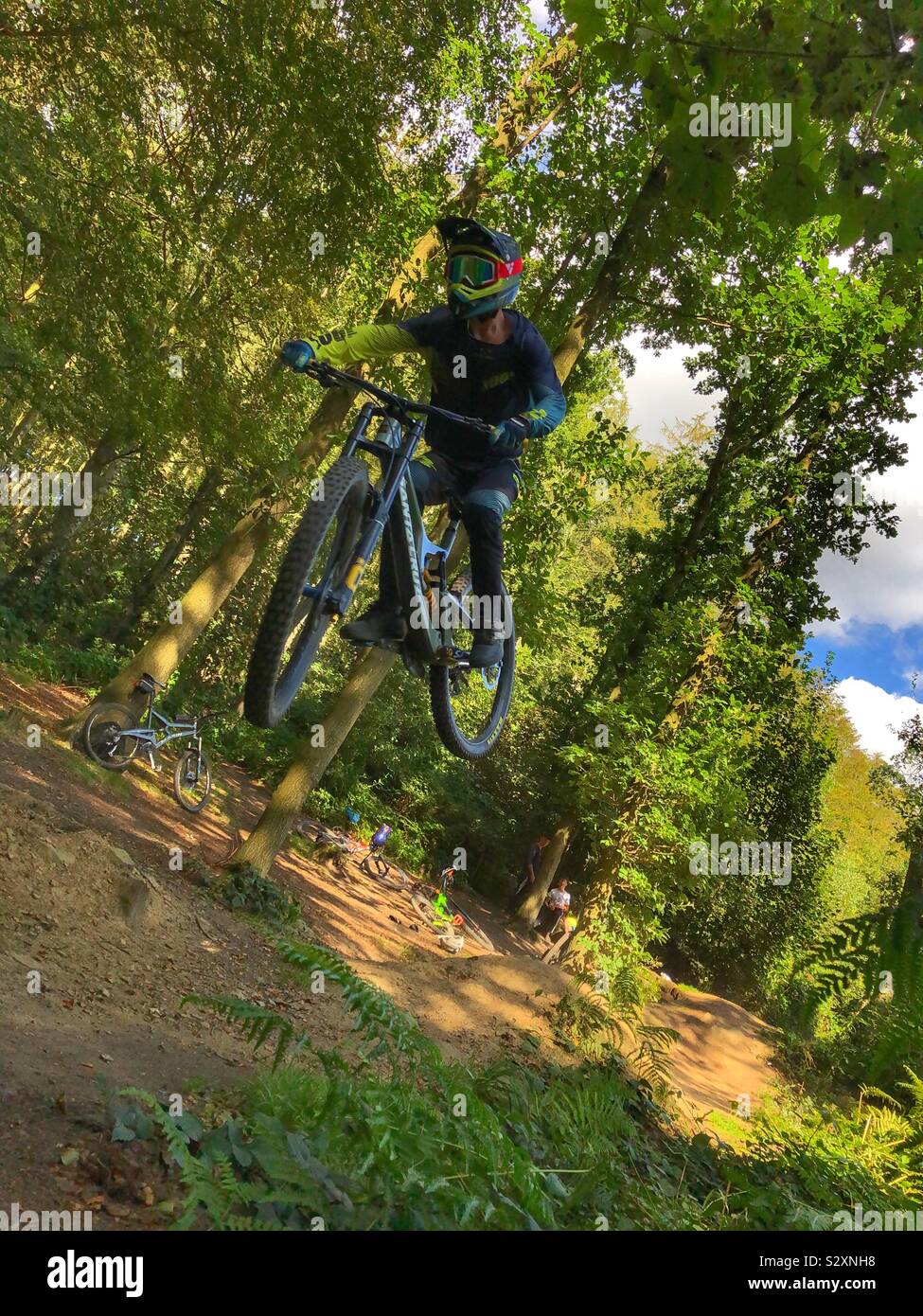 Downhill Mountain Biker jumping in Esholt Woods Stock Photo