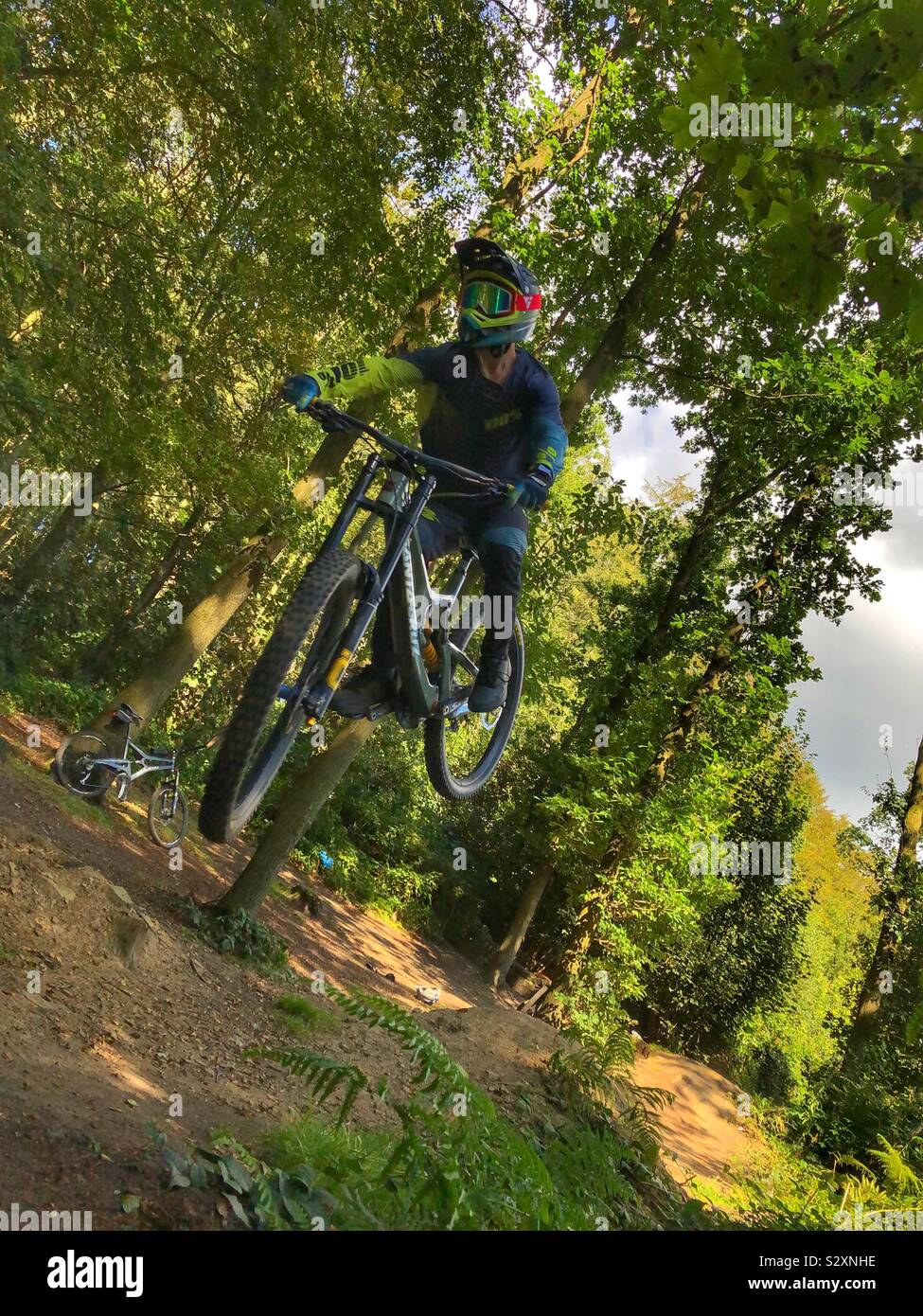 Downhill Mountain Biker jumping in Esholt Woods Stock Photo