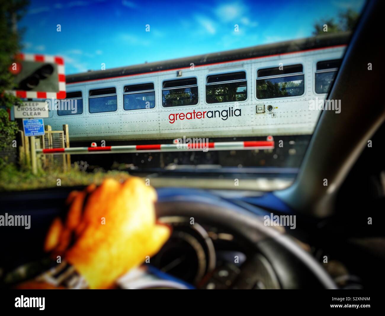 GreaterAnglia local service from Ipswich to Lowestoft going through at level crossing at Melton Suffolk UK - Smartphone Captured Stock Image
