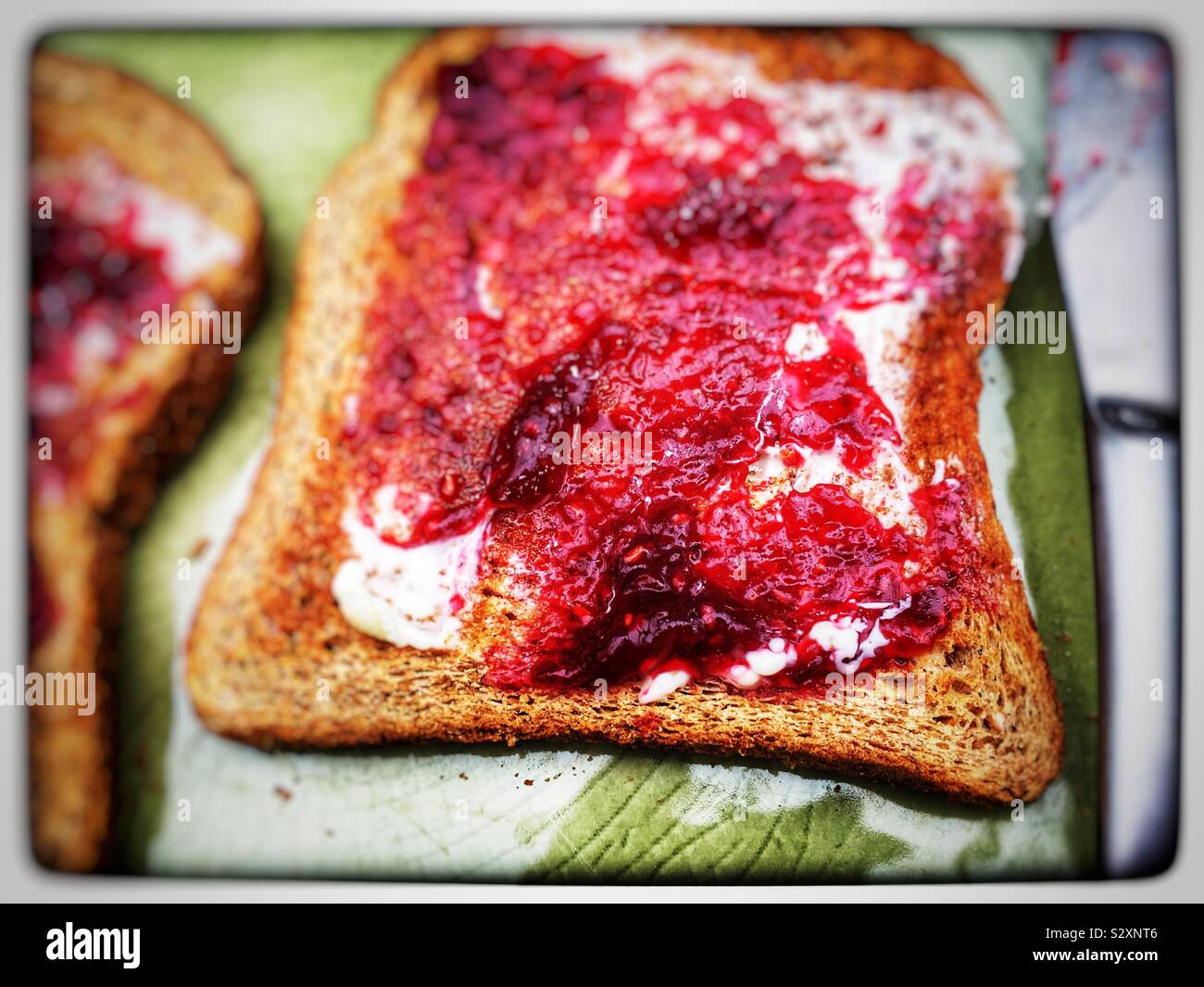 Raspberry jam on wholemeal toast Stock Photo Alamy