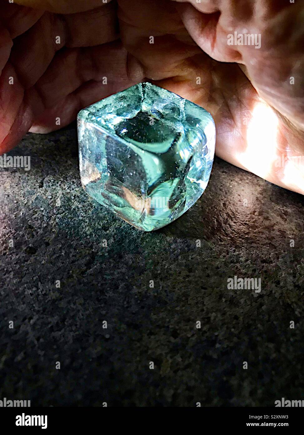 Cube of glass and man’s hand - Smartphone Captured Stock Image