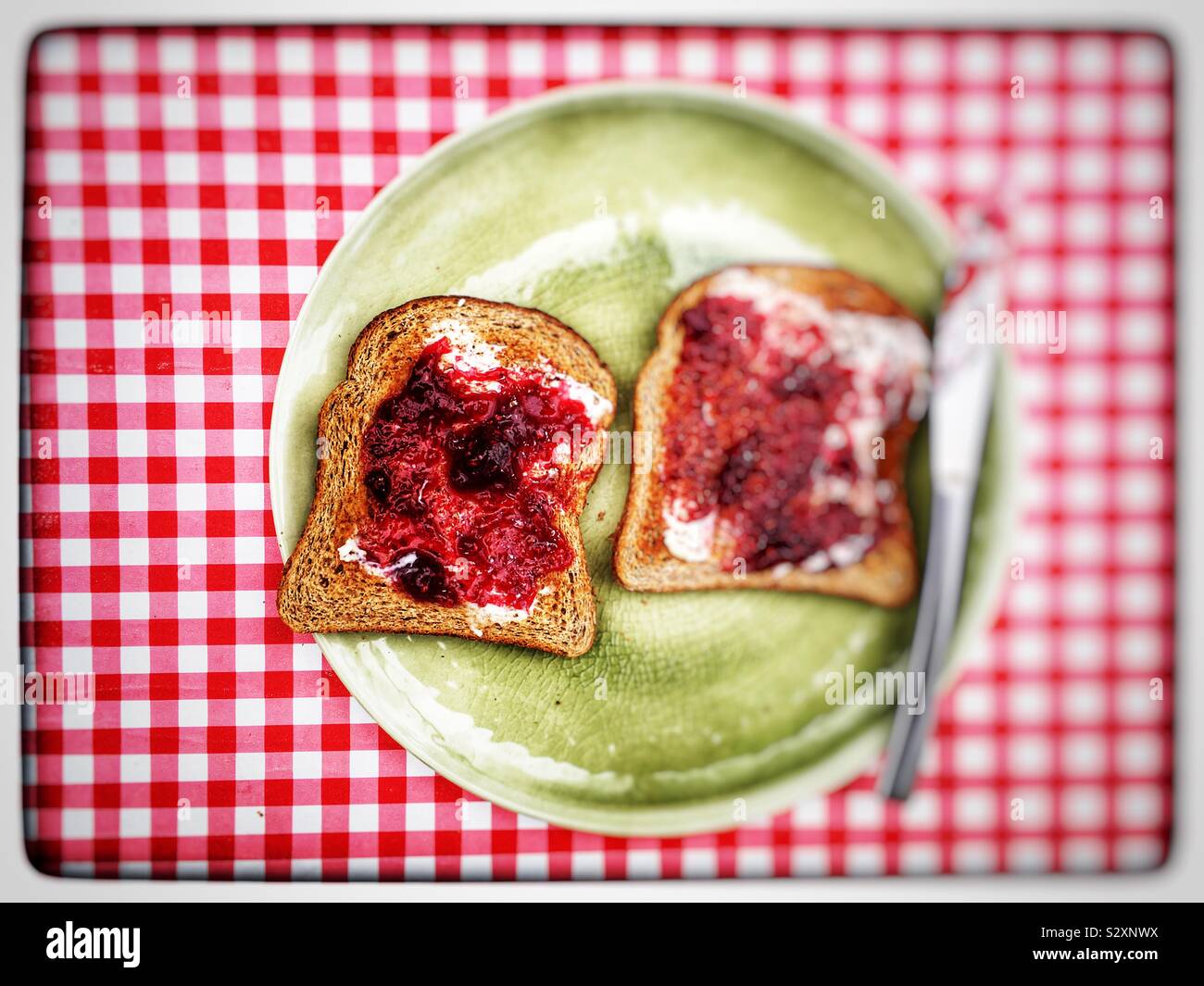 Raspberry jam on wholemeal toast Stock Photo Alamy