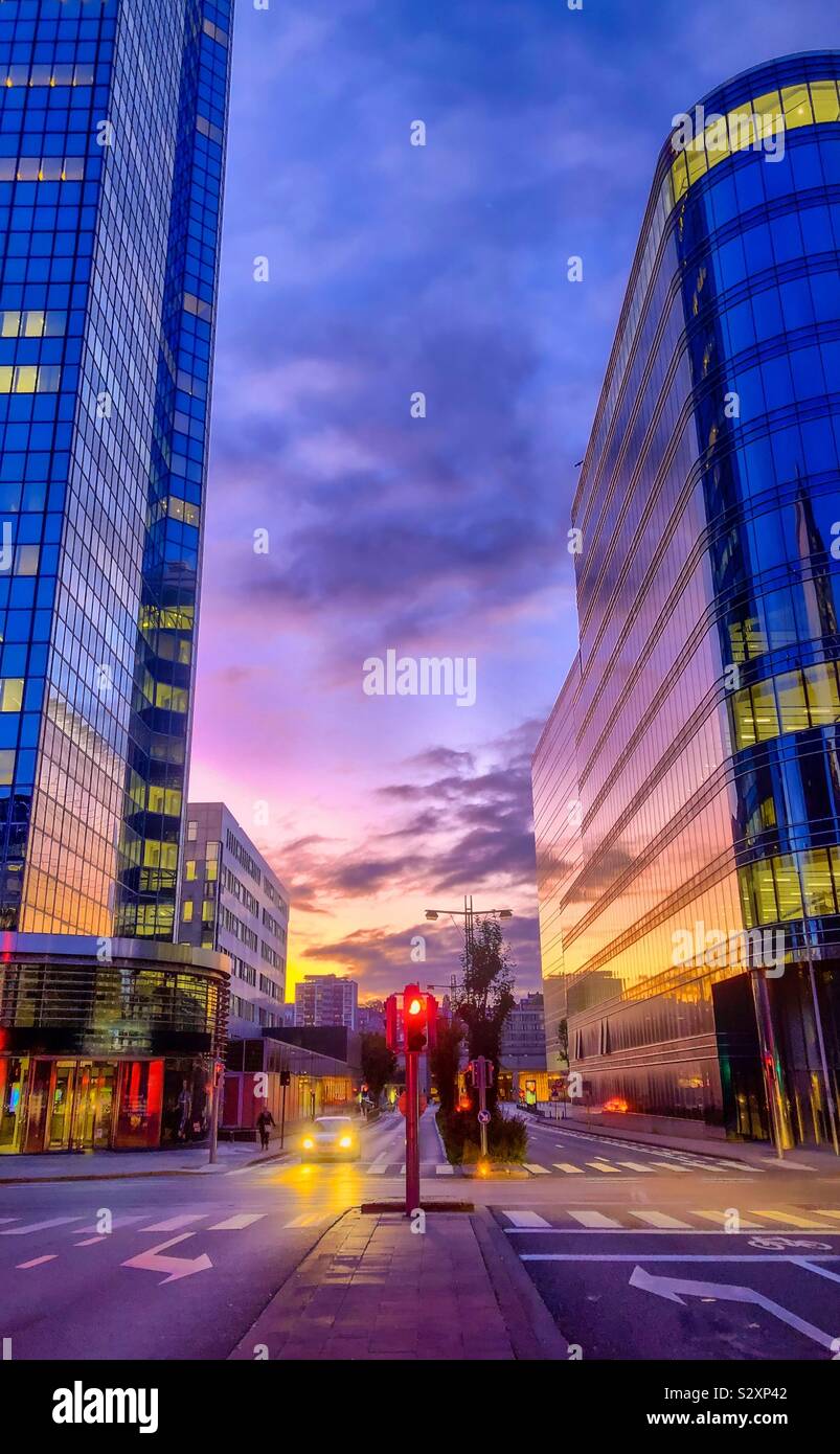 Colorful morning sky over the city streets, reflected in the glass windows of the office buildings of the business district of Brussels - Smartphone Captured Stock Image