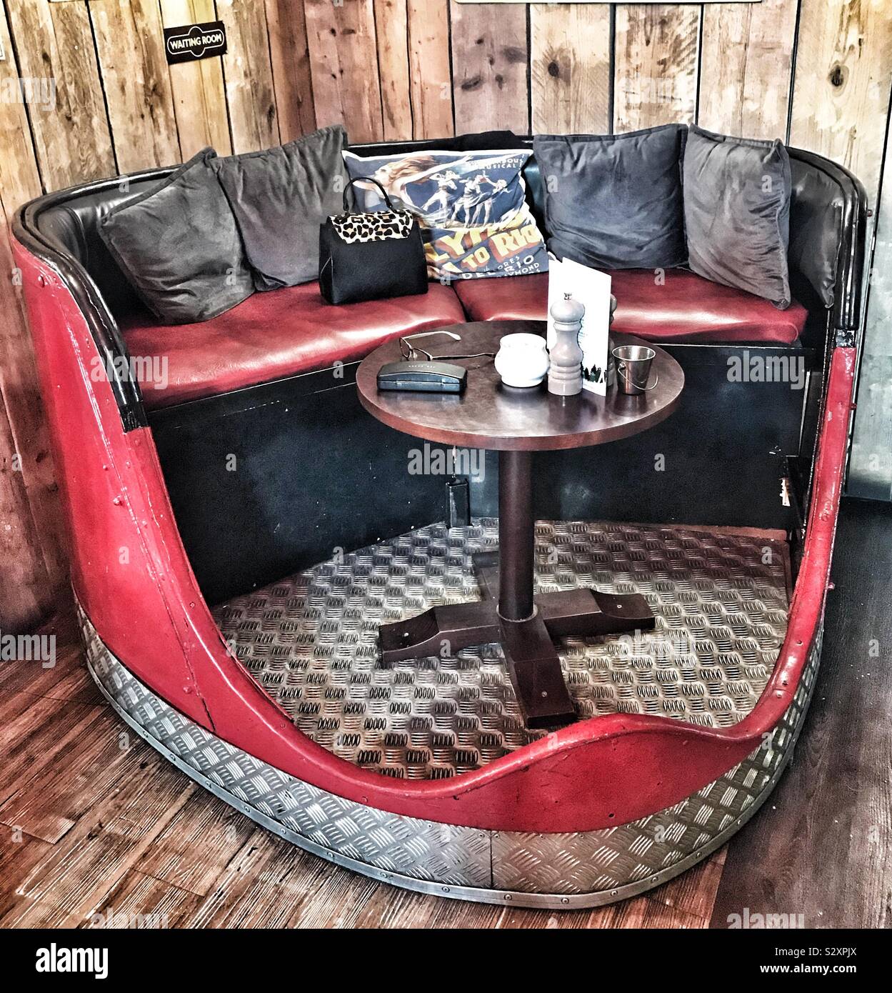Fairground Waltzer Seat Made into Tea Room Seating Area with Small Wooden Table In it and Cushions On The Seats - Welshpool, Wales Stock Photo