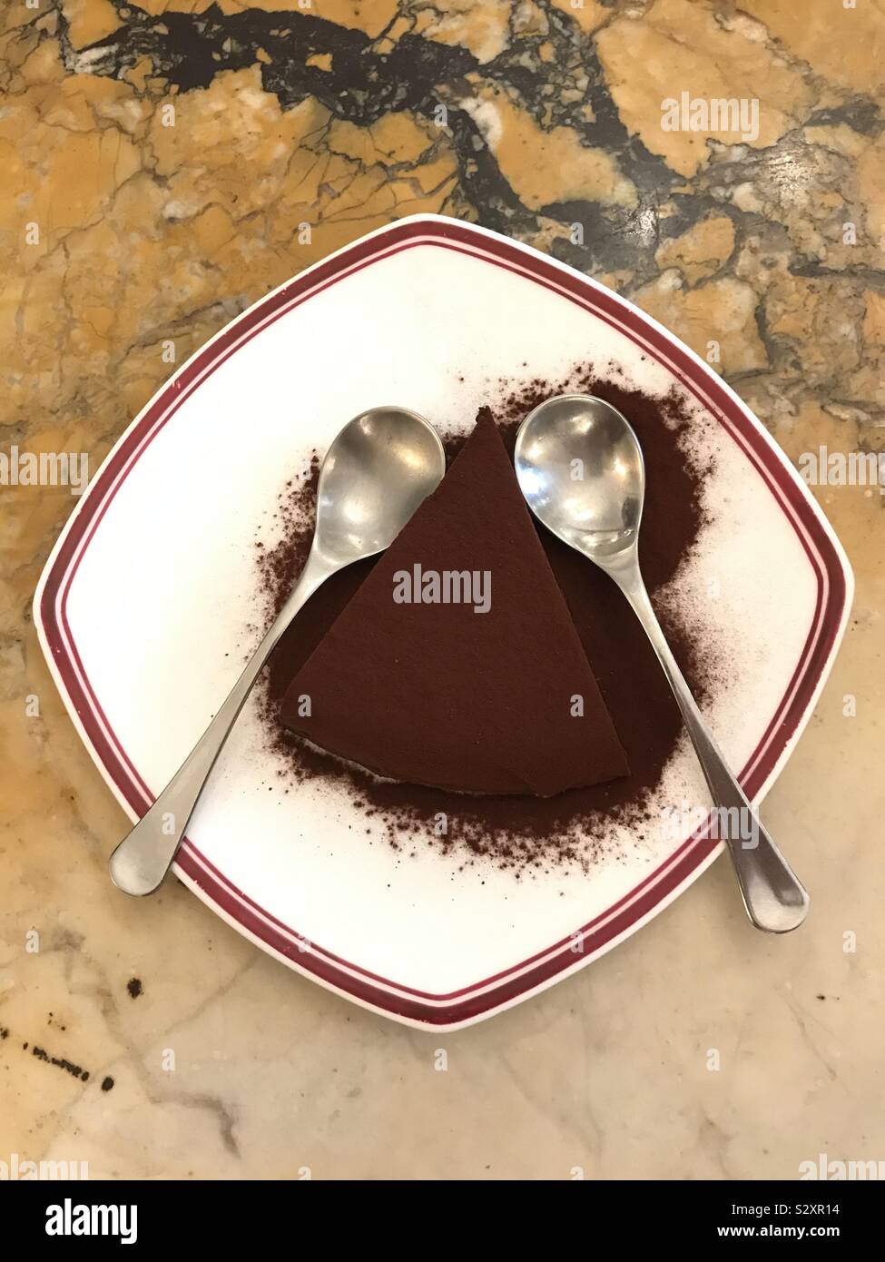 Plate of chocolate tart with 2 spoons on a marble table - Smartphone Captured Stock Image