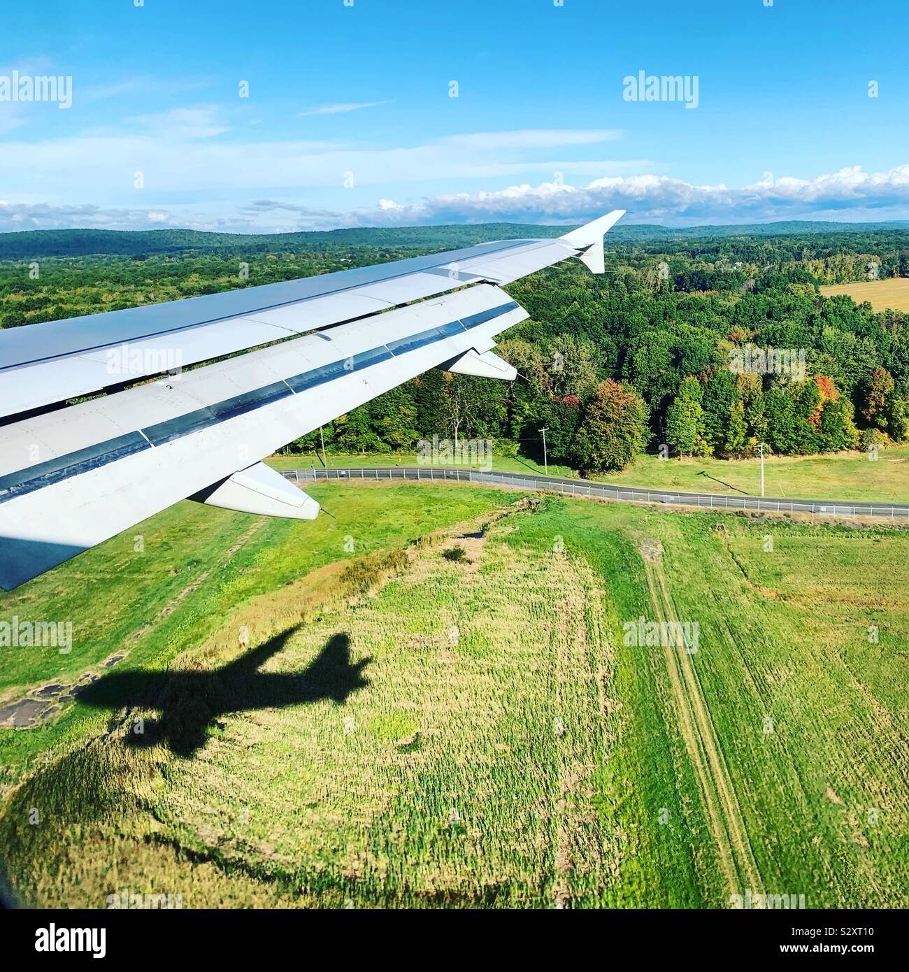 Airplane shadow seen under the wing while descending towards Bradley International Airport, Connecticut, United States - Smartphone Captured Stock Image