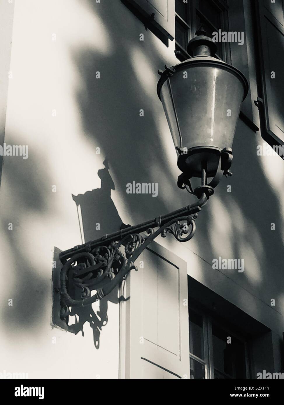 Street lantern hanging from wall in black and white Stock Photo
