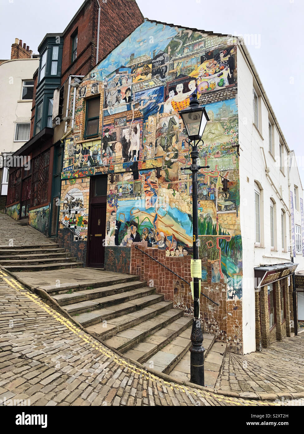 Painted gable end of a building on cobbled street in Scarborough, North Yorkshire Stock Photo