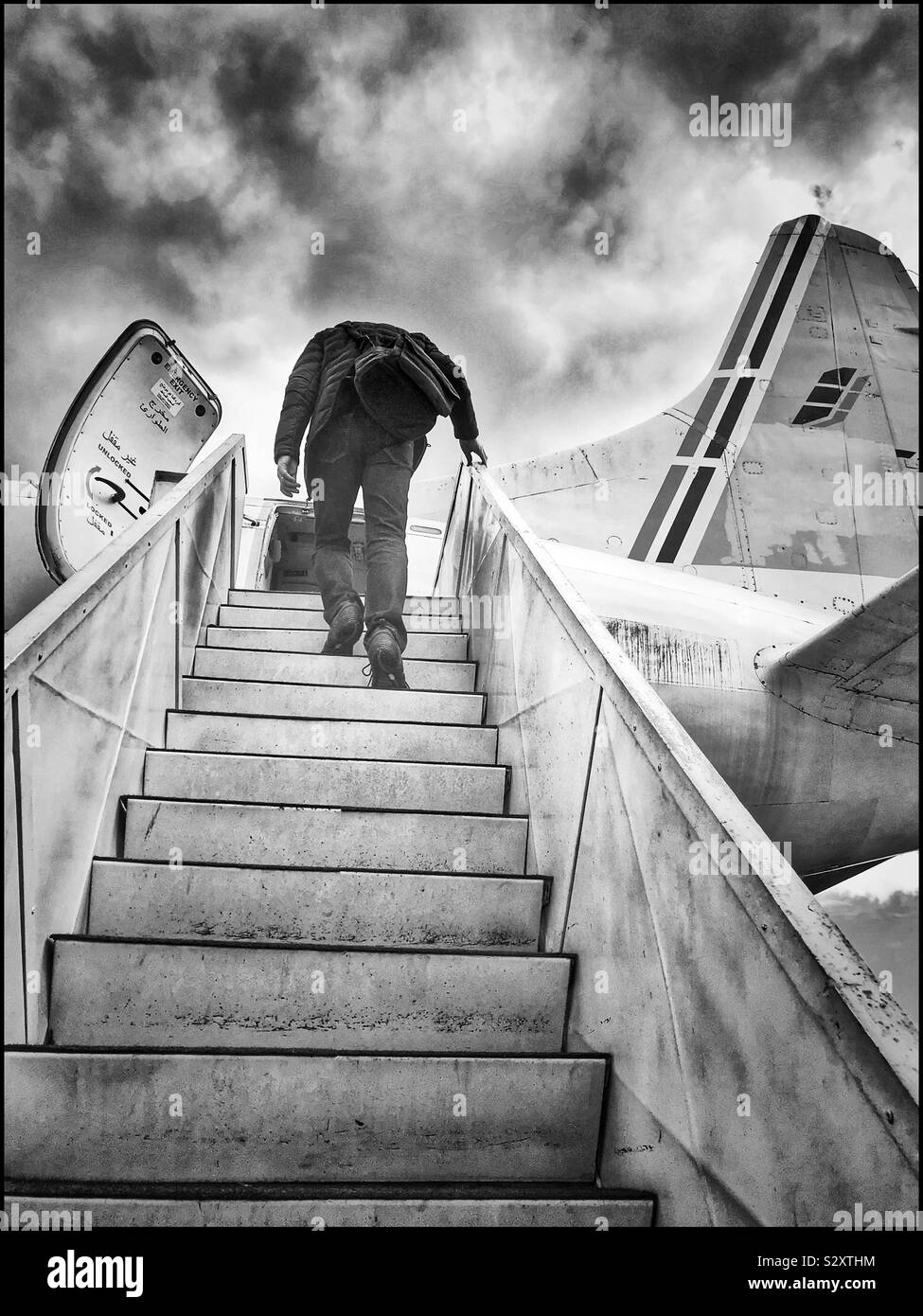 Man climbing up airplane stears. Black and white photo Stock Photo Alamy