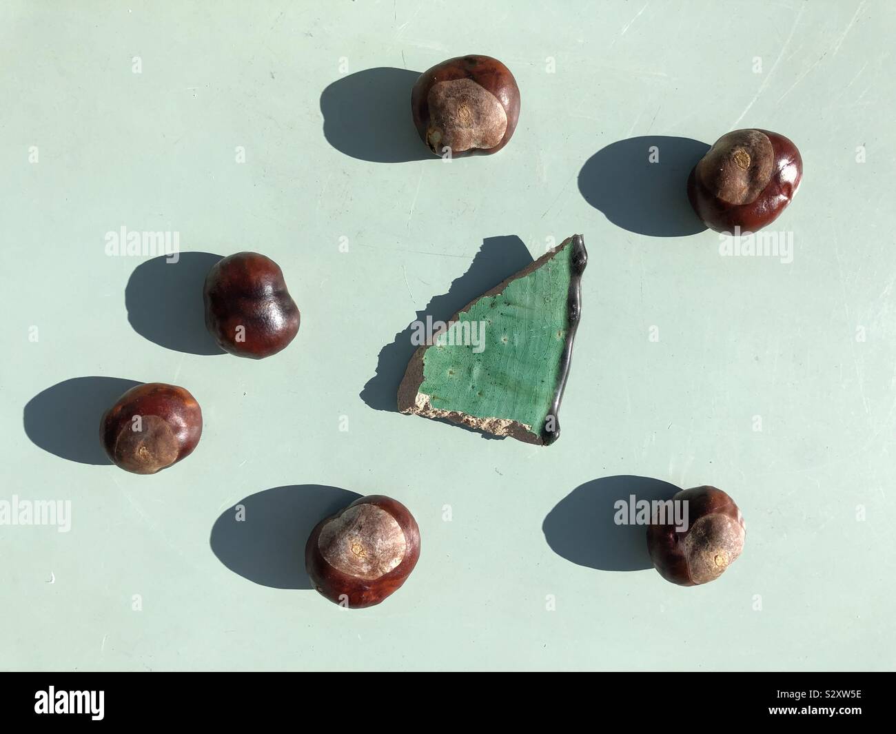 Minimalist composition with conker and a broken piece of clay pot - Smartphone Captured Stock Image