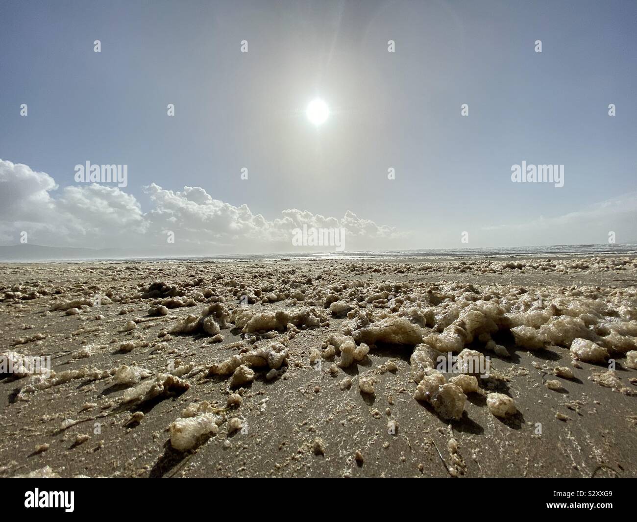 Sun, clouds and beach foam. Stock Photo