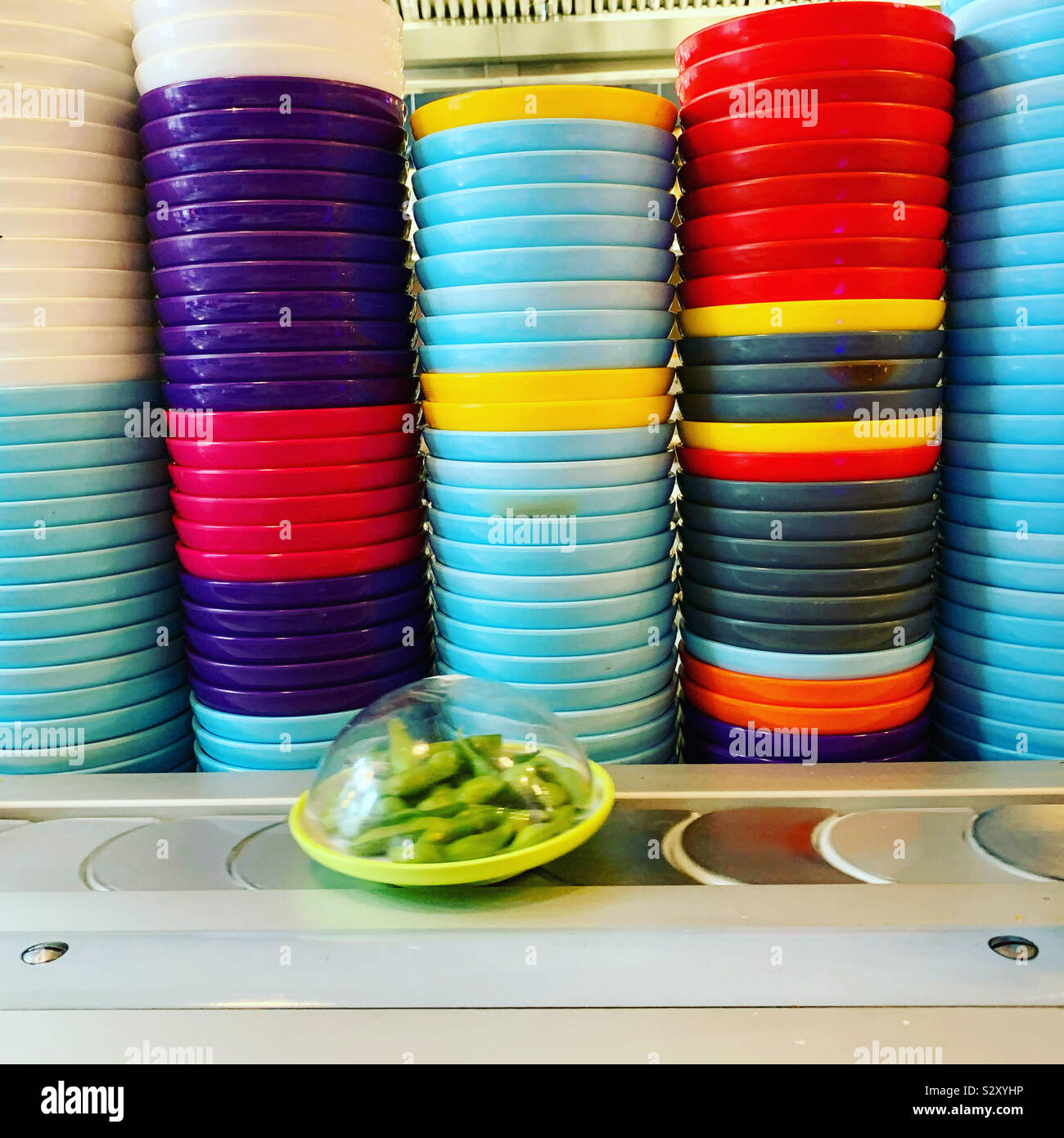 Bowl of green edamame beans on a sushi restaurant conveyor belt carousel. Stock Photo