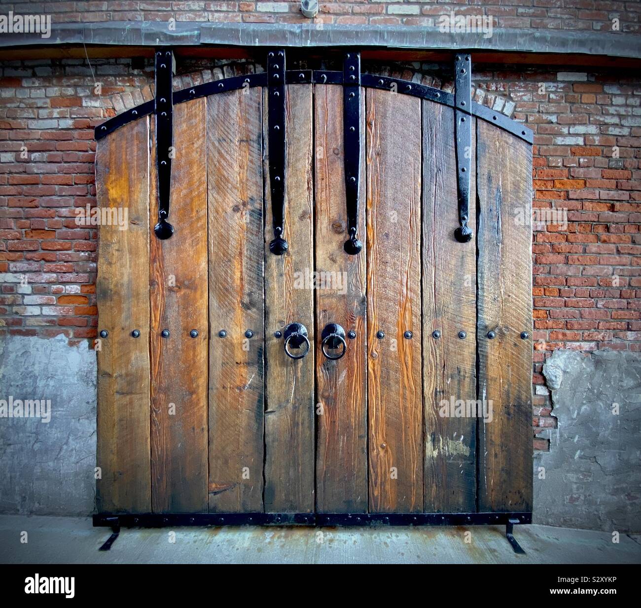 Old and weathered barn styled door in historic brick warehouse building - Smartphone Captured Stock Image